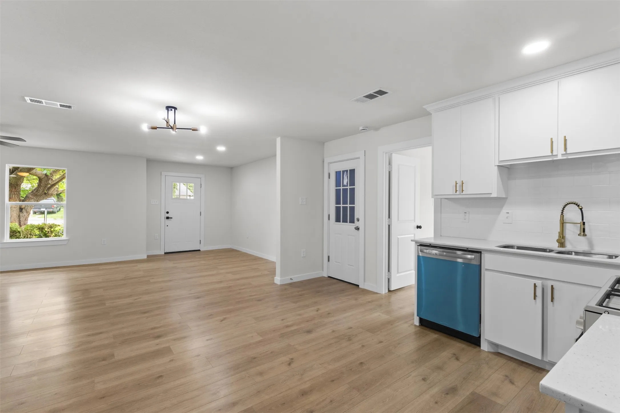 Open-concept living space featuring wood-finish flooring, recessed lighting, and a contemporary ceiling fixture