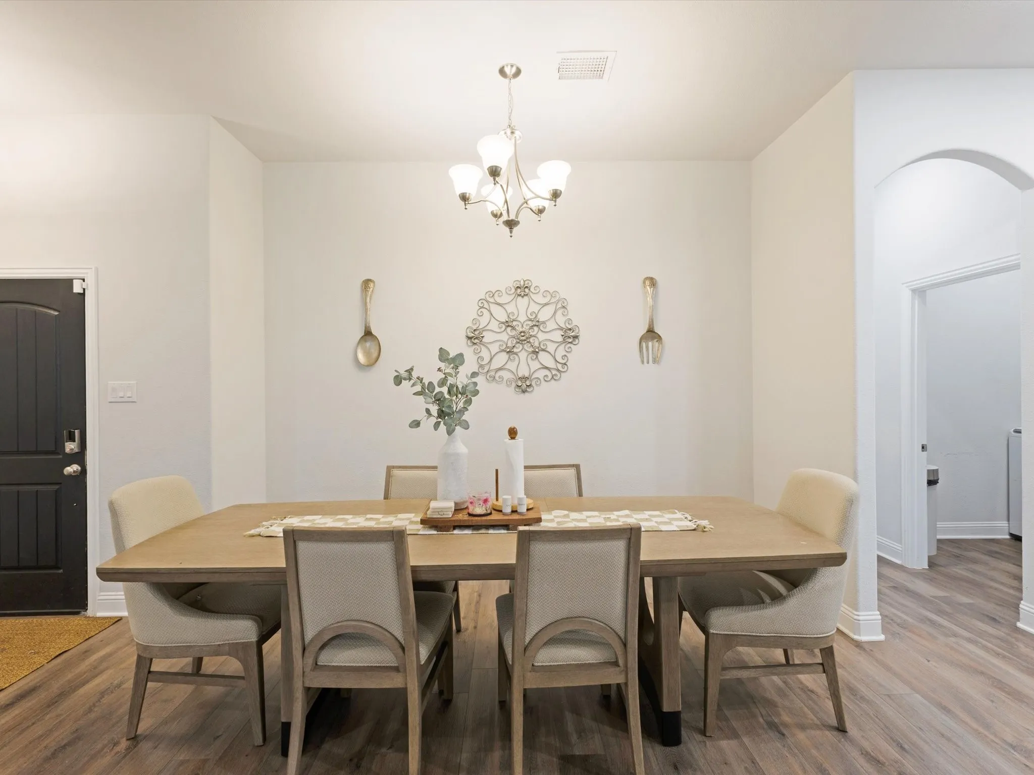 Dining area featuring wood-finish flooring and a central chandelier