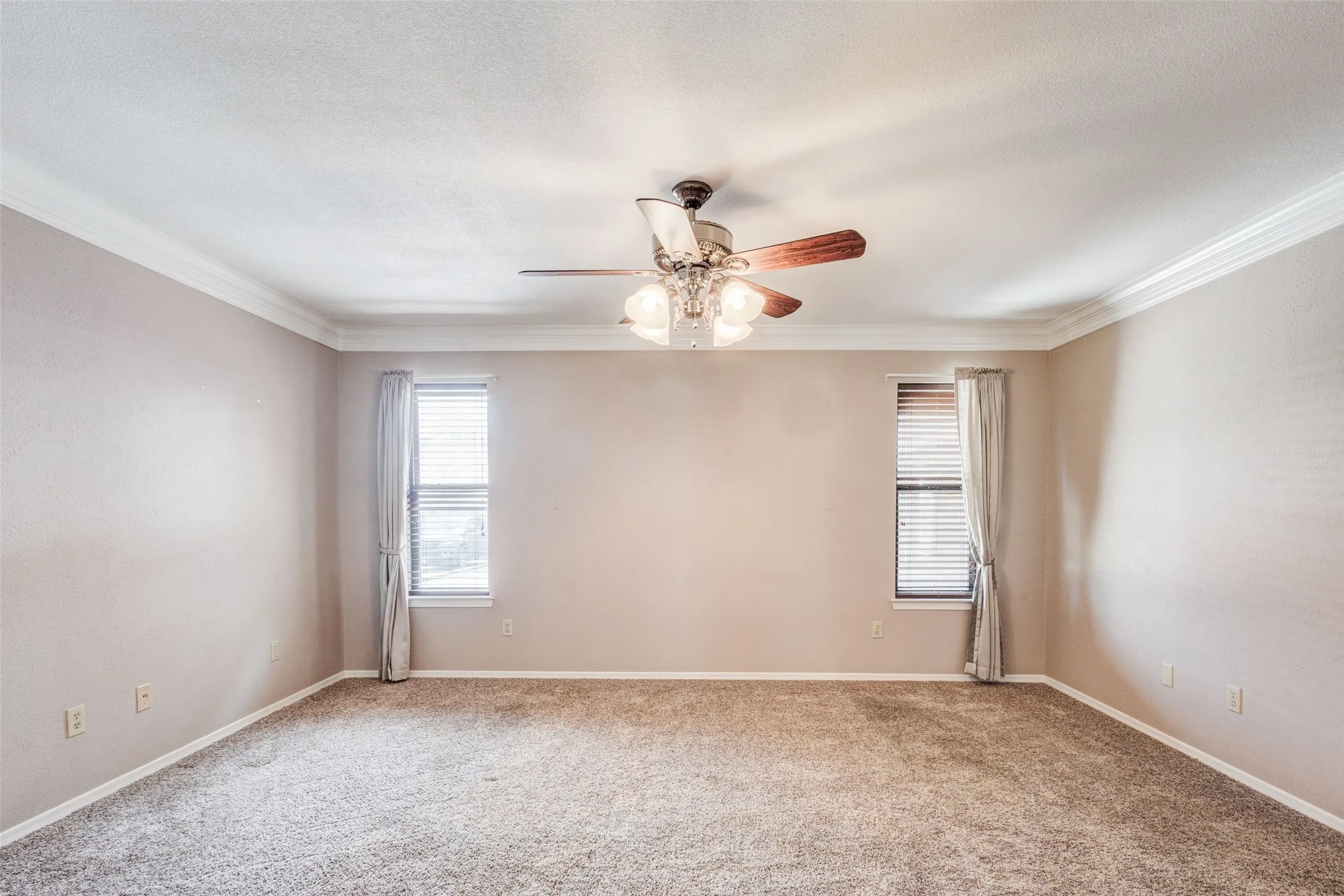  featuring neutral carpeting, light beige wall tones, and white crown molding