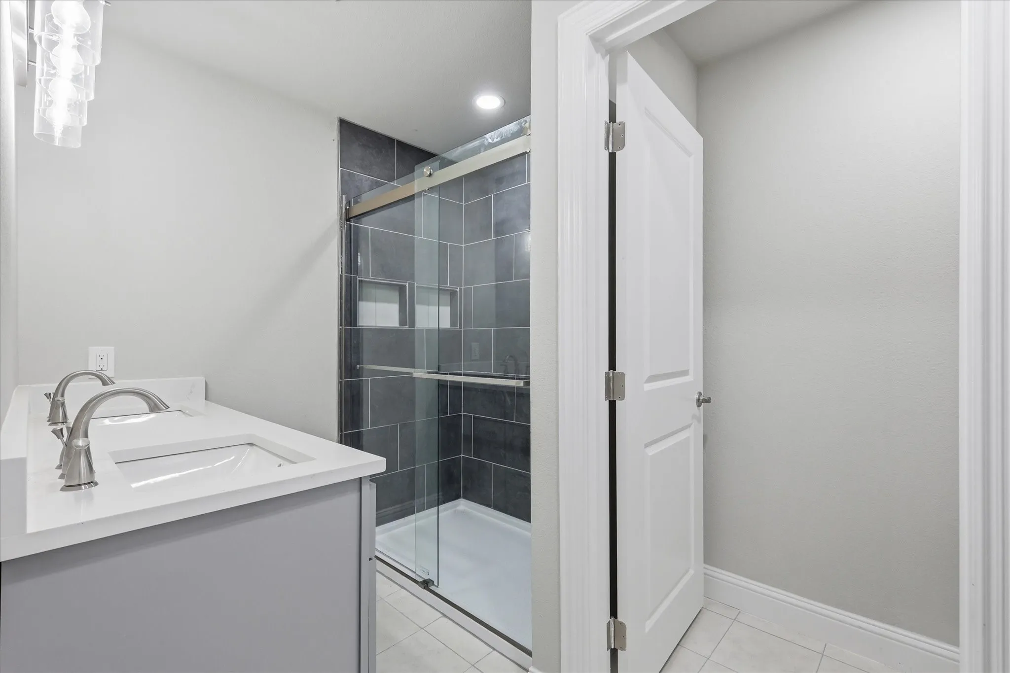 Bathroom featuring a double vanity with undermount sinks, a quartz countertop, and brushed nickel hardware