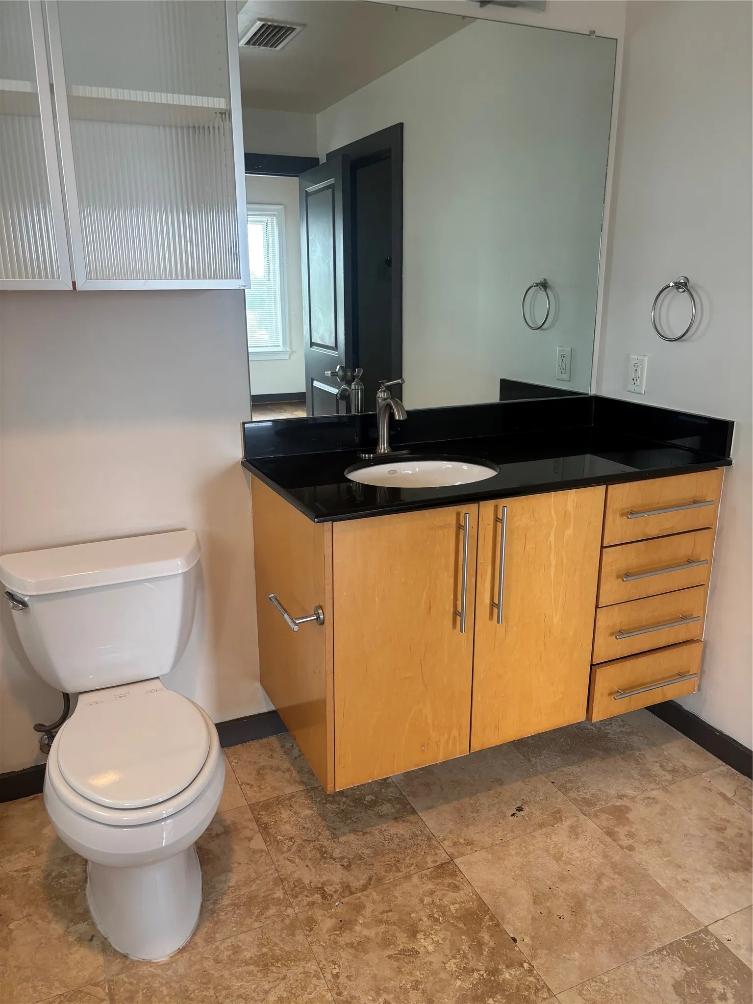 Floating wood-finish vanity with a black countertop and an integrated sink