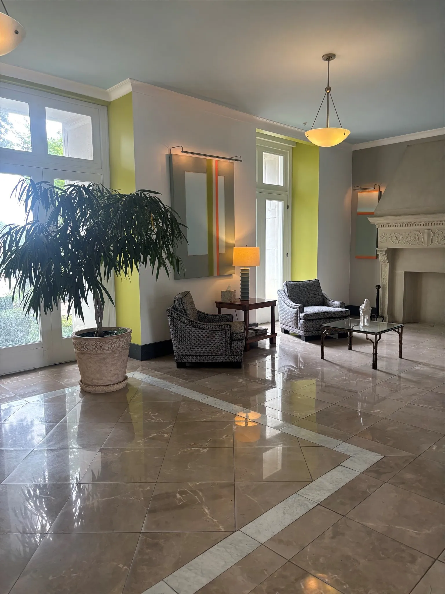 Polished tile flooring with a light-toned inlay, tall windows, a decorative fireplace mantel, and crown molding