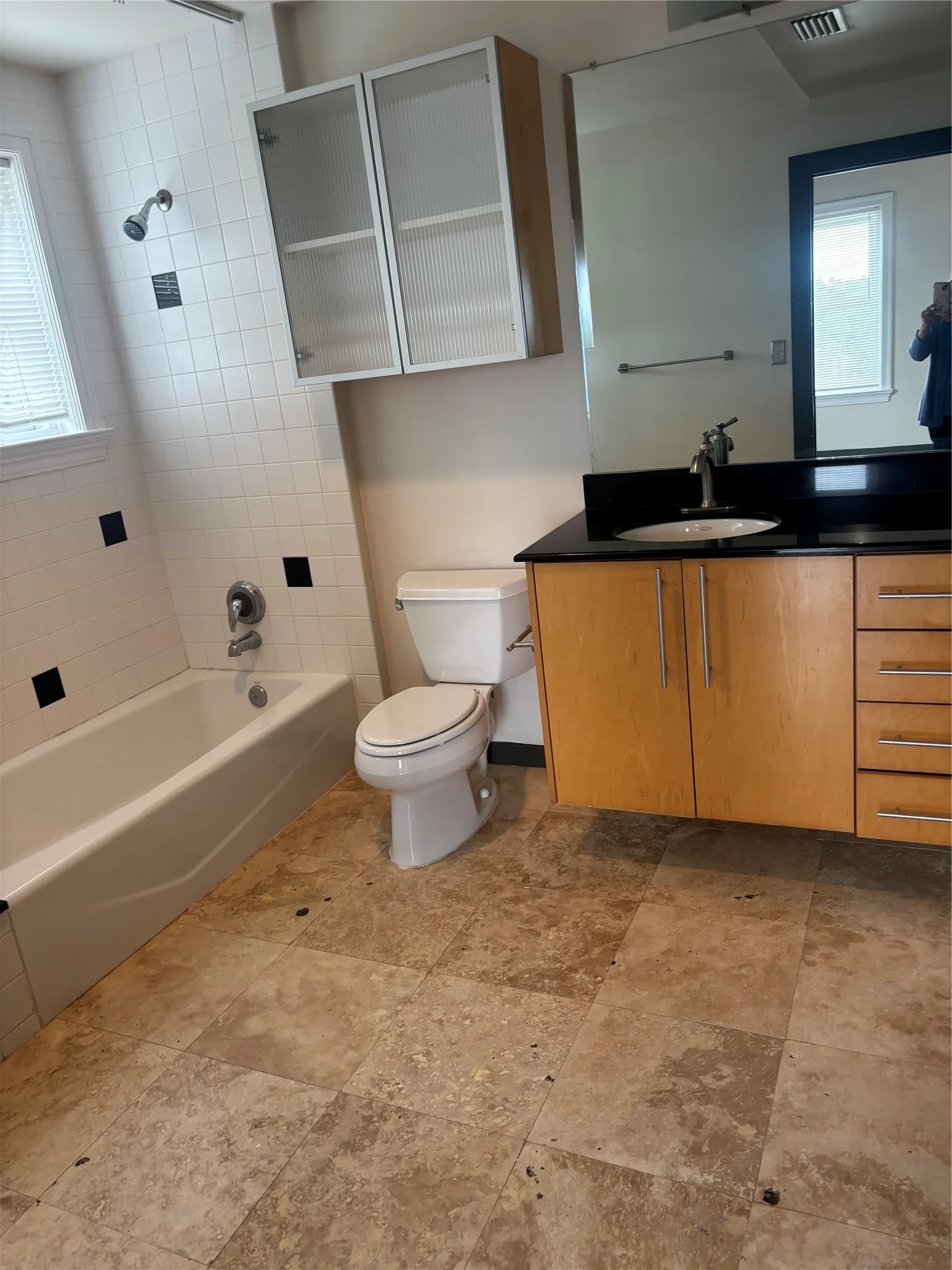 Bathroom featuring a soaking tub with subway tile surround and decorative black accent tiles