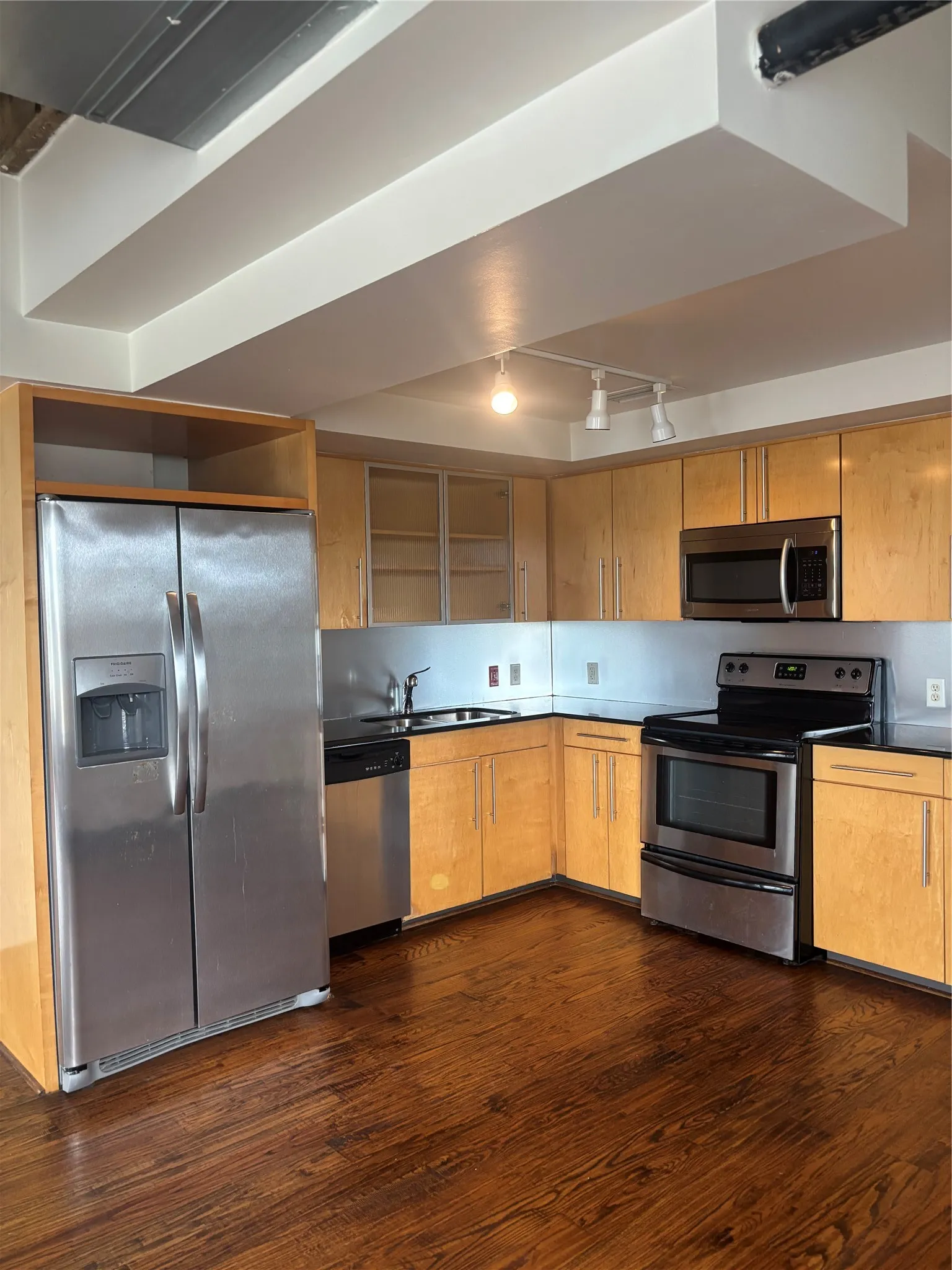 Modern kitchen featuring wood-finish cabinetry and dark countertops