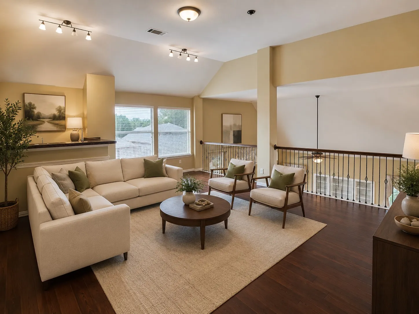 Hardwood-style flooring throughout this open-concept room features an angled ceiling with track lighting