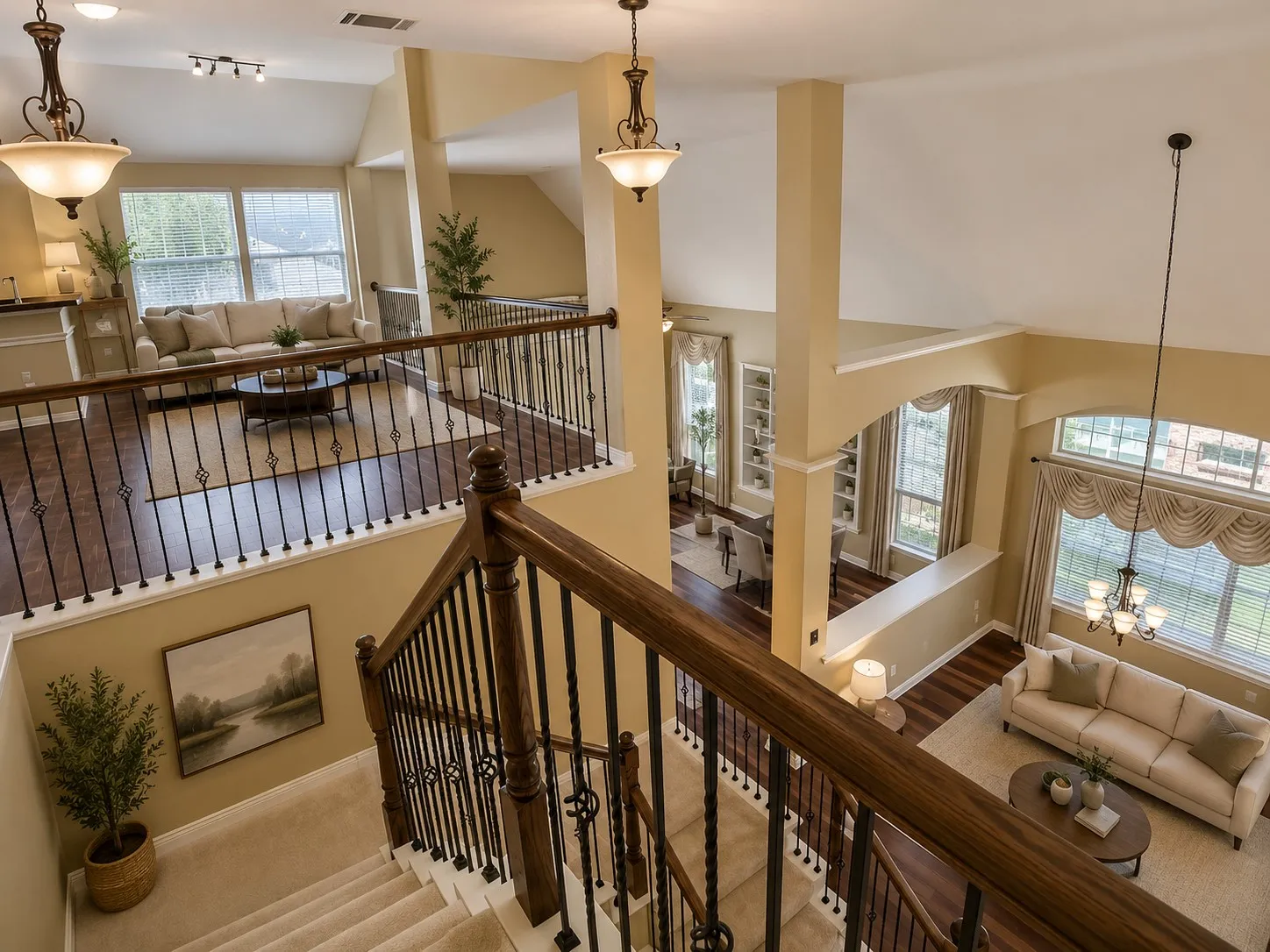 Multi-level interior featuring a carpeted staircase with wood and wrought iron railing, vaulted ceilings, and wood-finish flooring