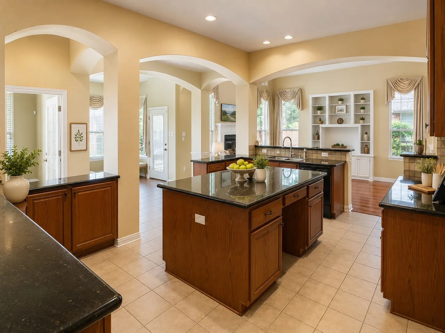 Spacious kitchen featuring dark countertops, light-toned tiled flooring, and multiple archways