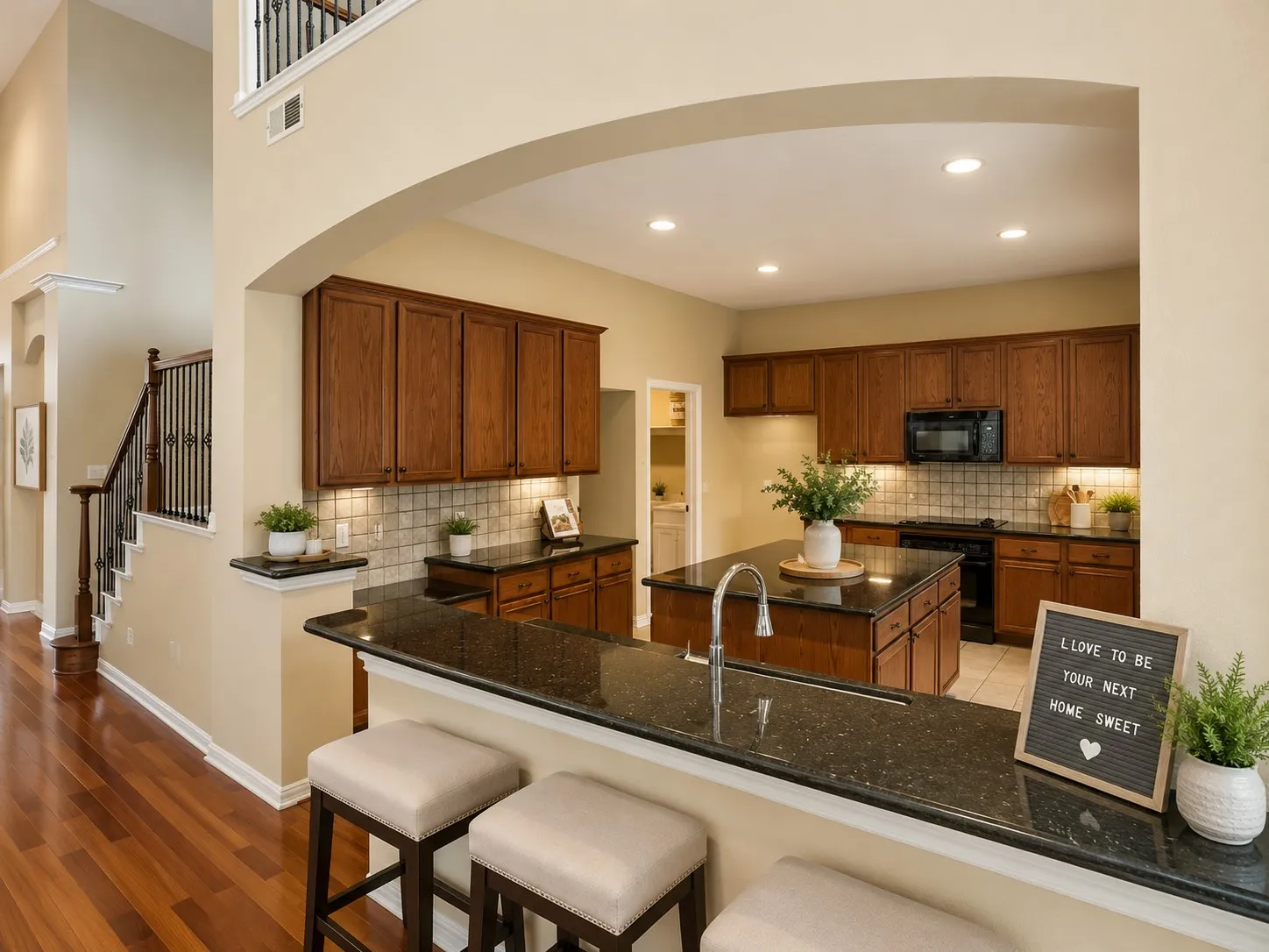 Gourmet kitchen featuring rich wood cabinetry, dark stone countertops, tile backsplash, and recessed lighting