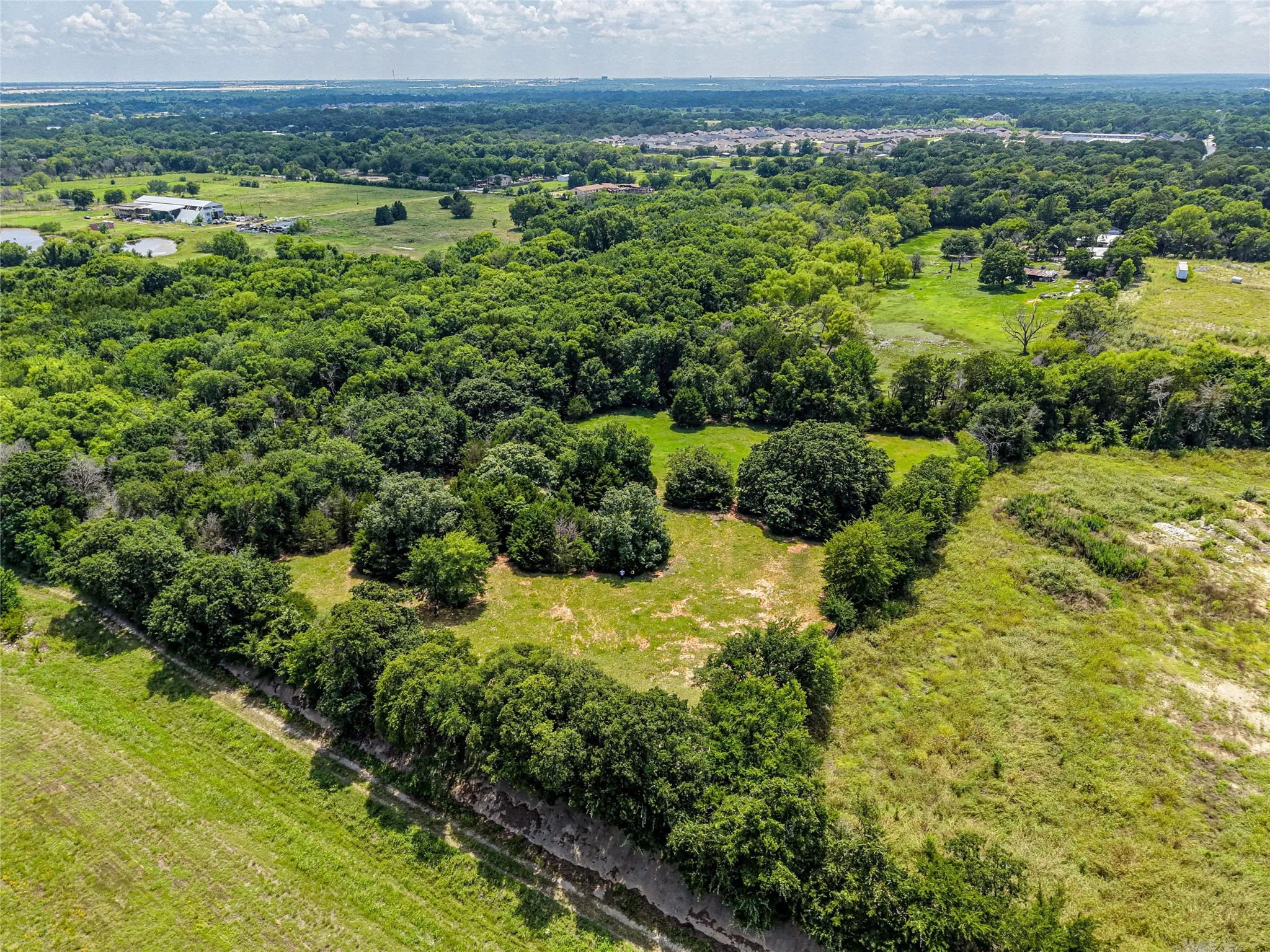 Expansive undeveloped property featuring mature tree lines and open grassy areas