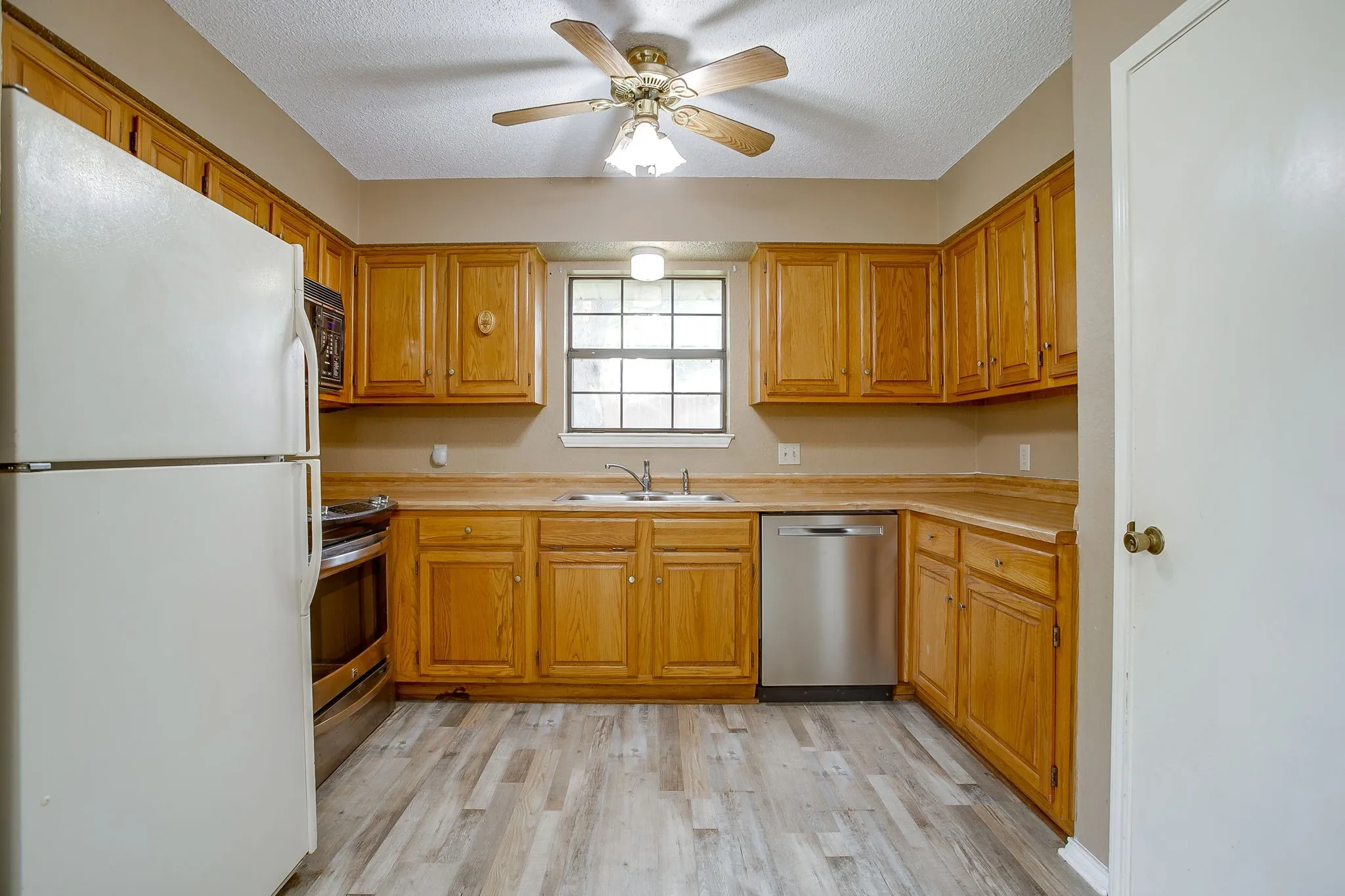 Kitchen featuring wood-finish cabinetry, light wood-finish countertops, and wood-finish flooring