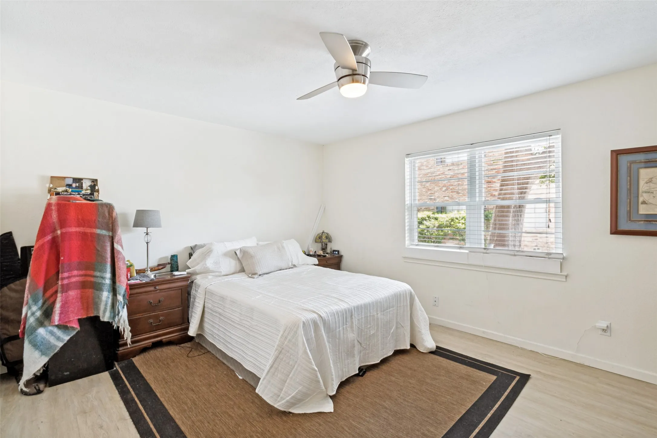 Bedroom featuring light wood-finish flooring and a ceiling fan with integrated lighting