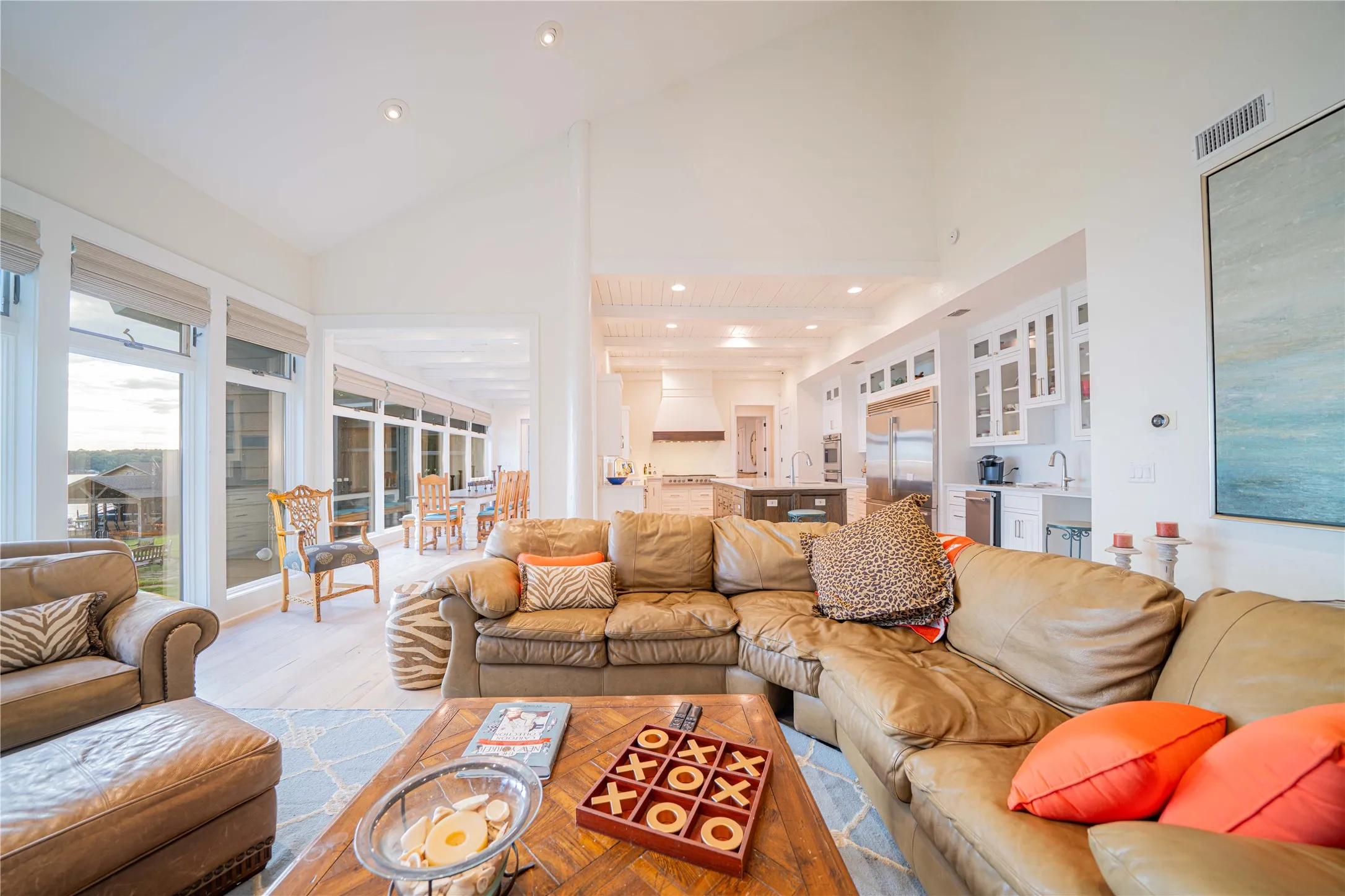 Living room featuring high vaulted ceiling, light wood-style flooring, and recessed lighting
