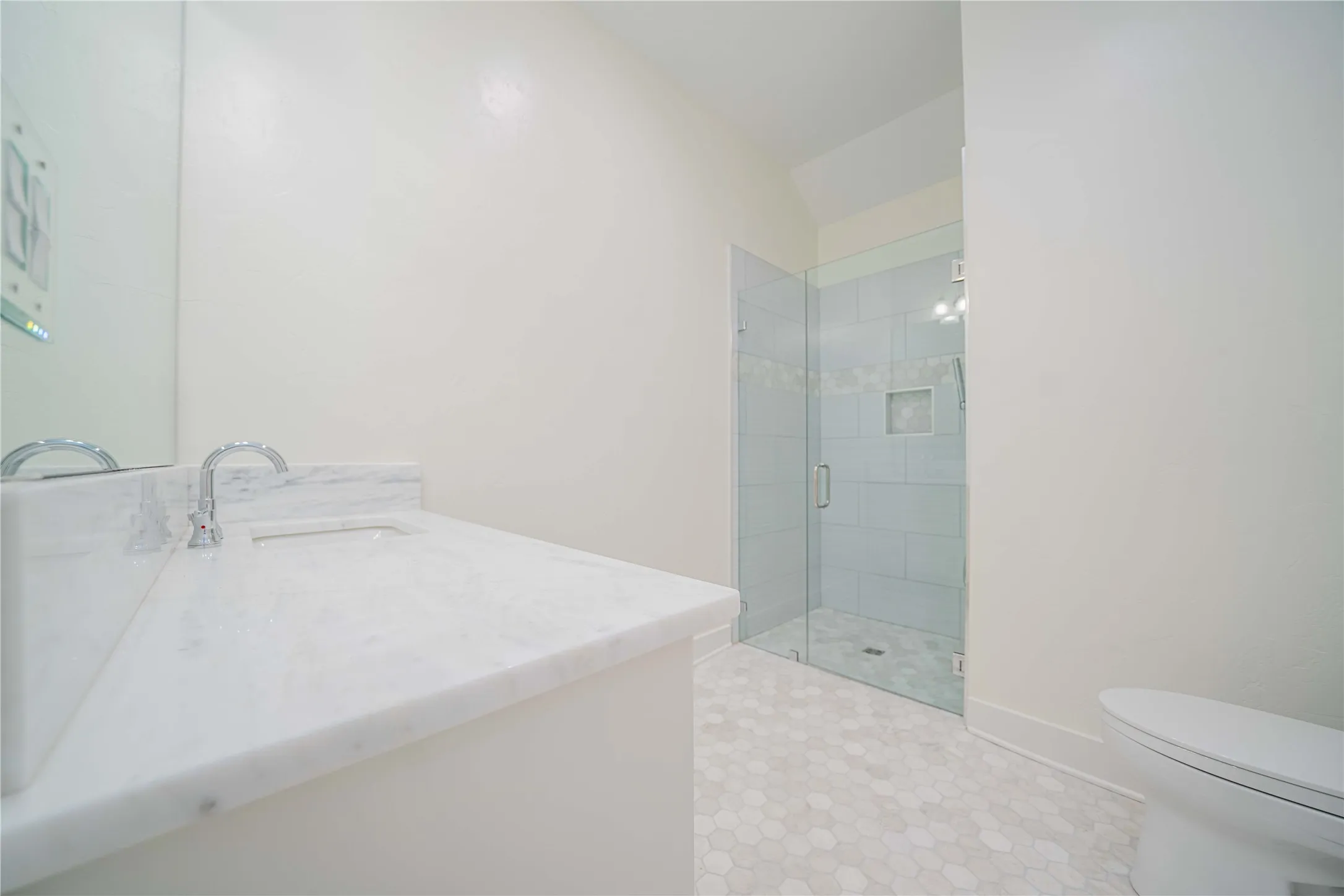 Bathroom with vanity, a shower stall, vaulted ceiling, and tile patterned flooring