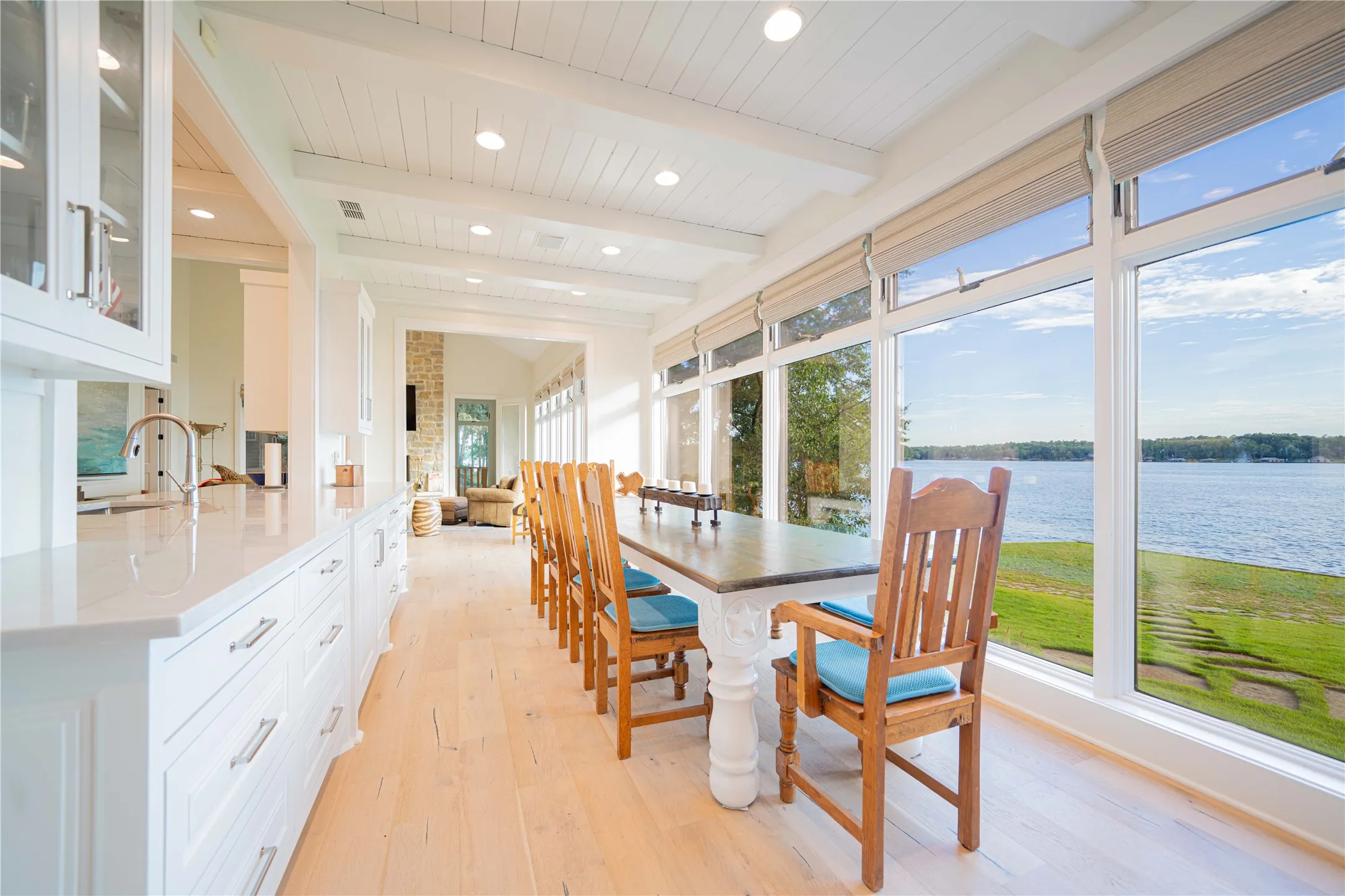 Sunroom with healthy amount of natural light, beamed ceiling, and a water view