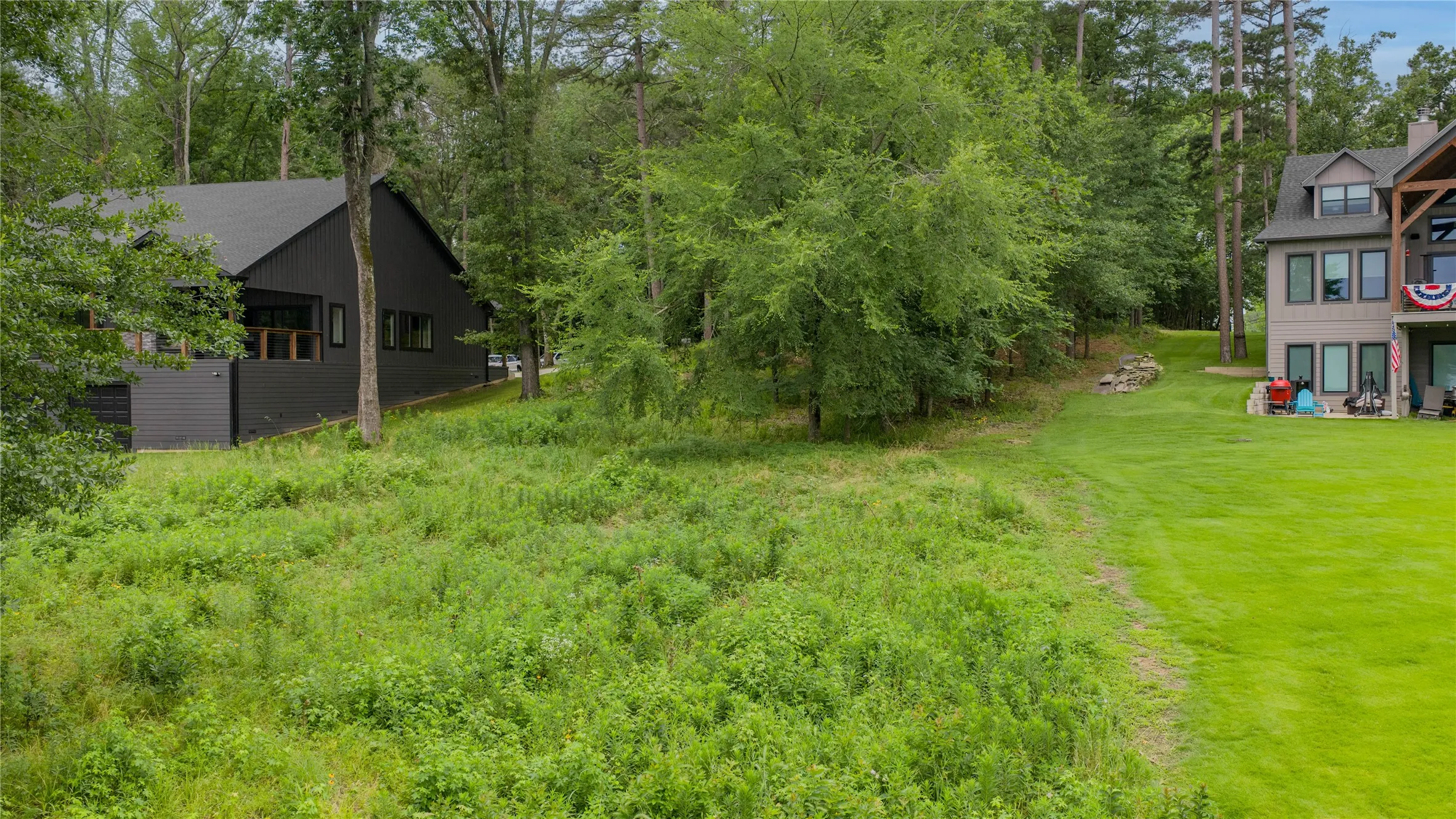 Expansive green lawn with forested borders