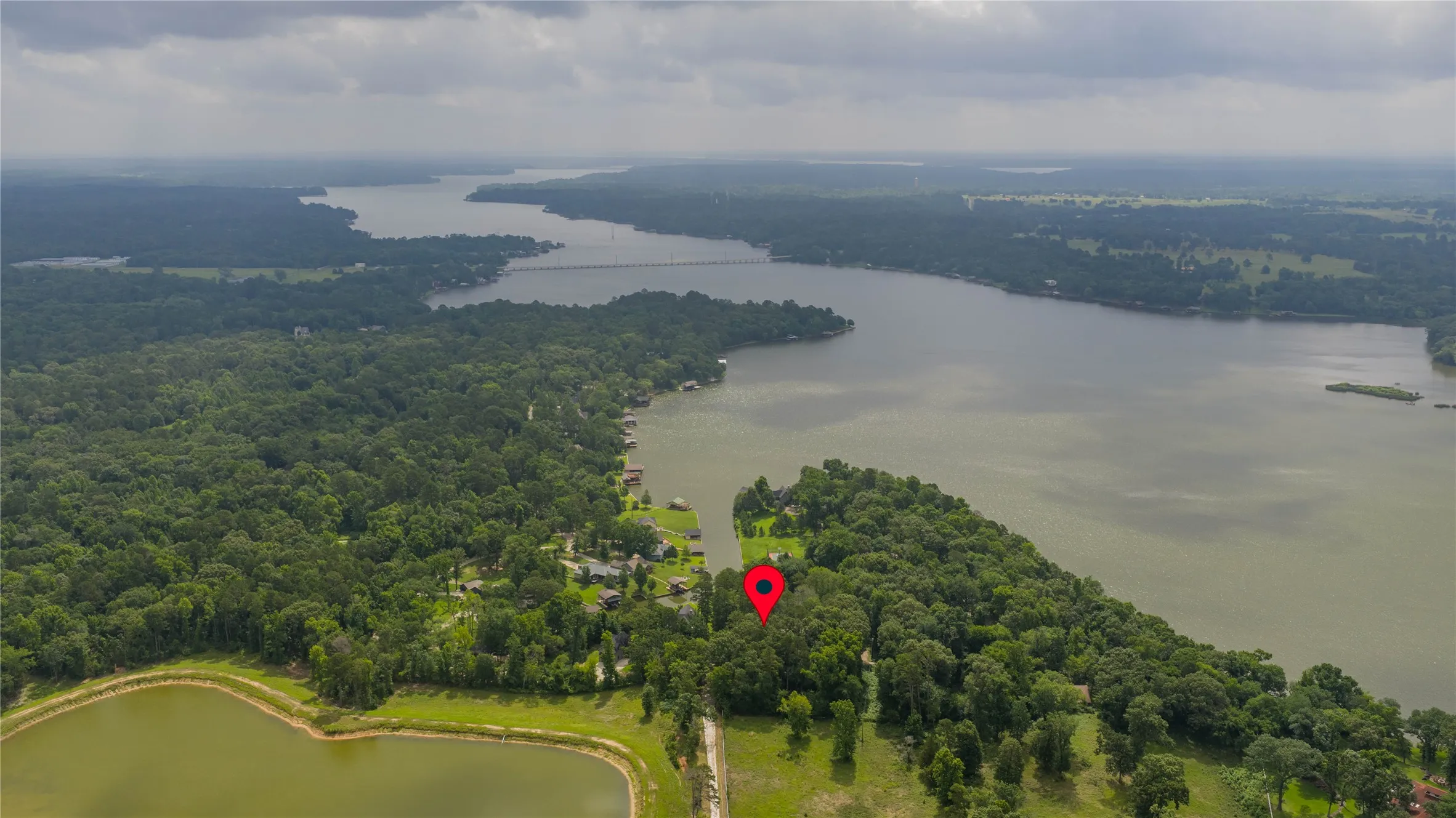 Expansive aerial perspective showcasing a significant body of water bordered by dense forestland