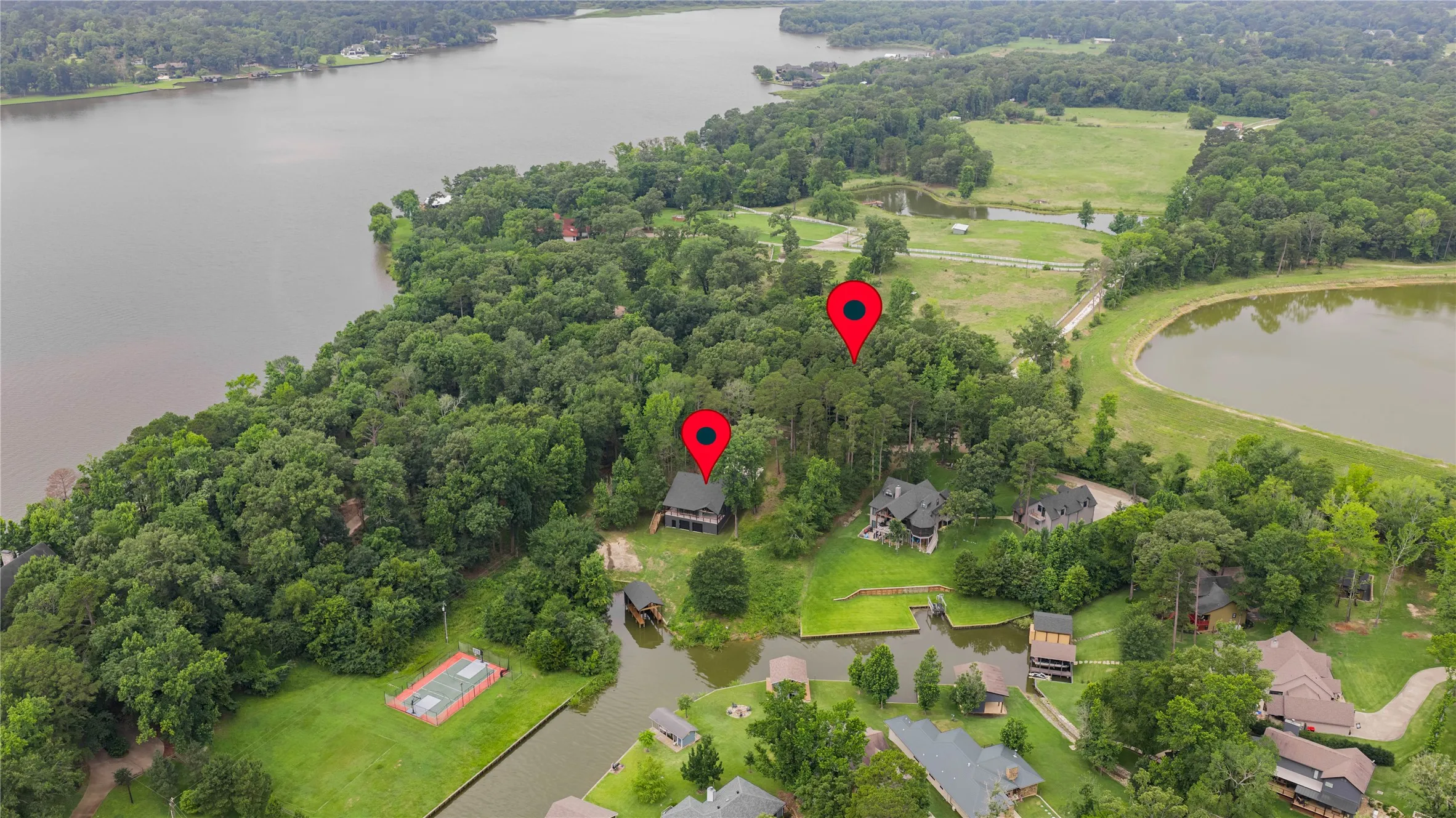 Aerial perspective showcasing a waterfront property with extensive tree coverage
