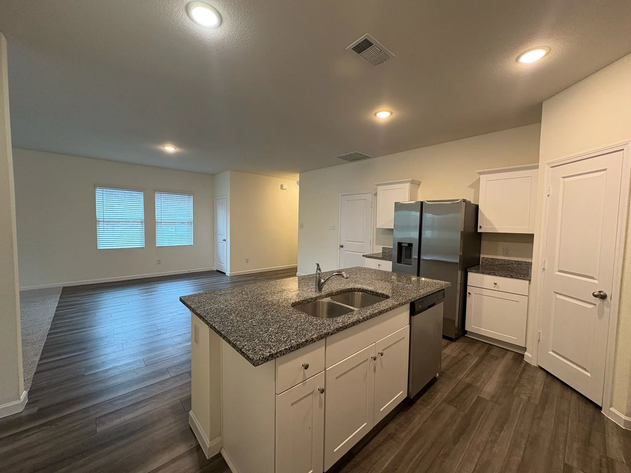 Kitchen island featuring a double-basin stainless steel sink and granite countertop