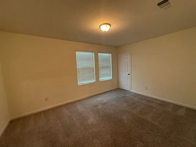 Neutral-toned room featuring a warm carpeted floor and light-colored walls
