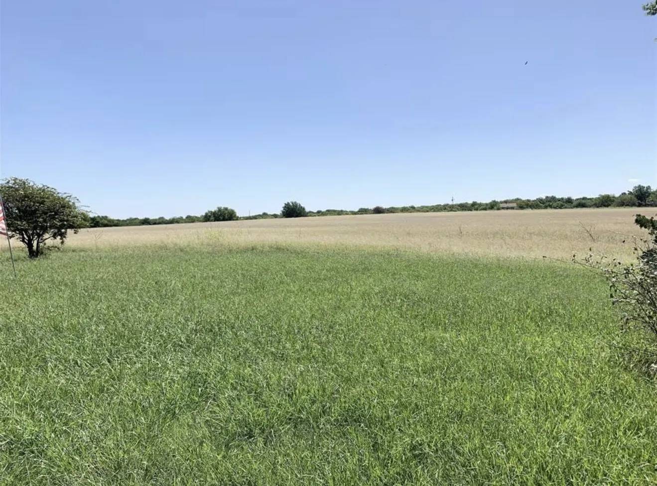 Expansive open land featuring a combination of green and golden fields