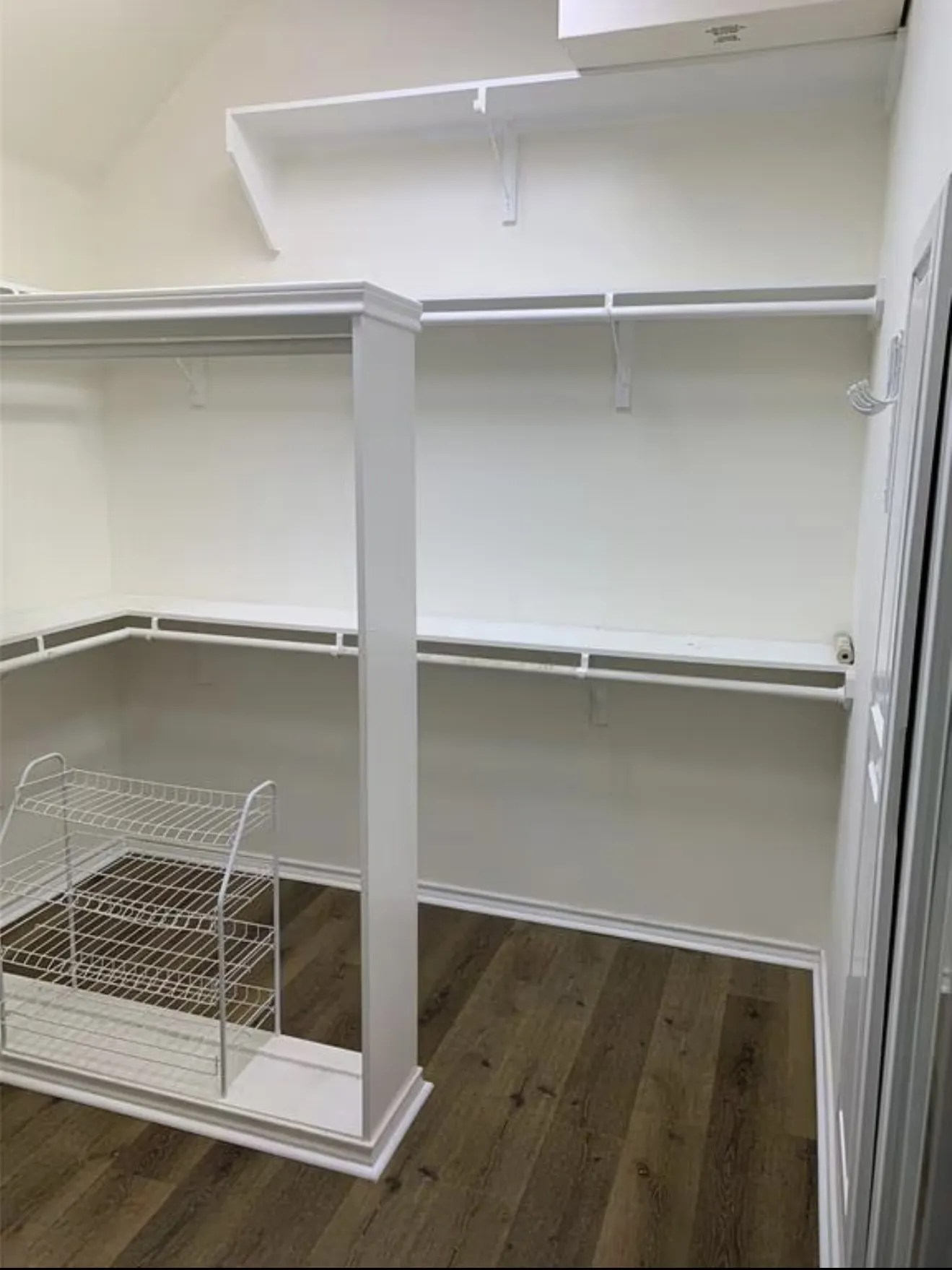 Walk-in closet with white shelving and hanging rods