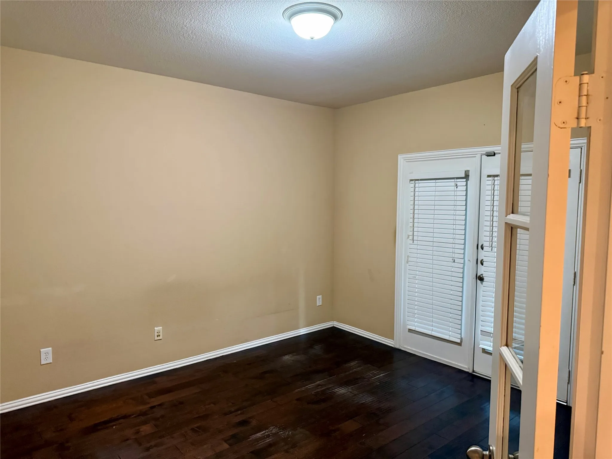 Room featuring warm neutral wall tones and dark wood-finish flooring