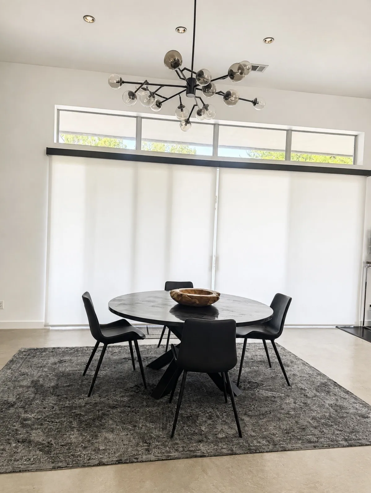 High ceilings with recessed lighting, an architectural chandelier, and clerestory windows with roller shades