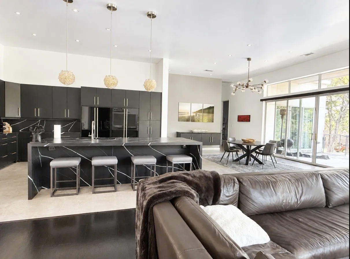 Modern kitchen featuring black cabinetry and stone countertops with white veining