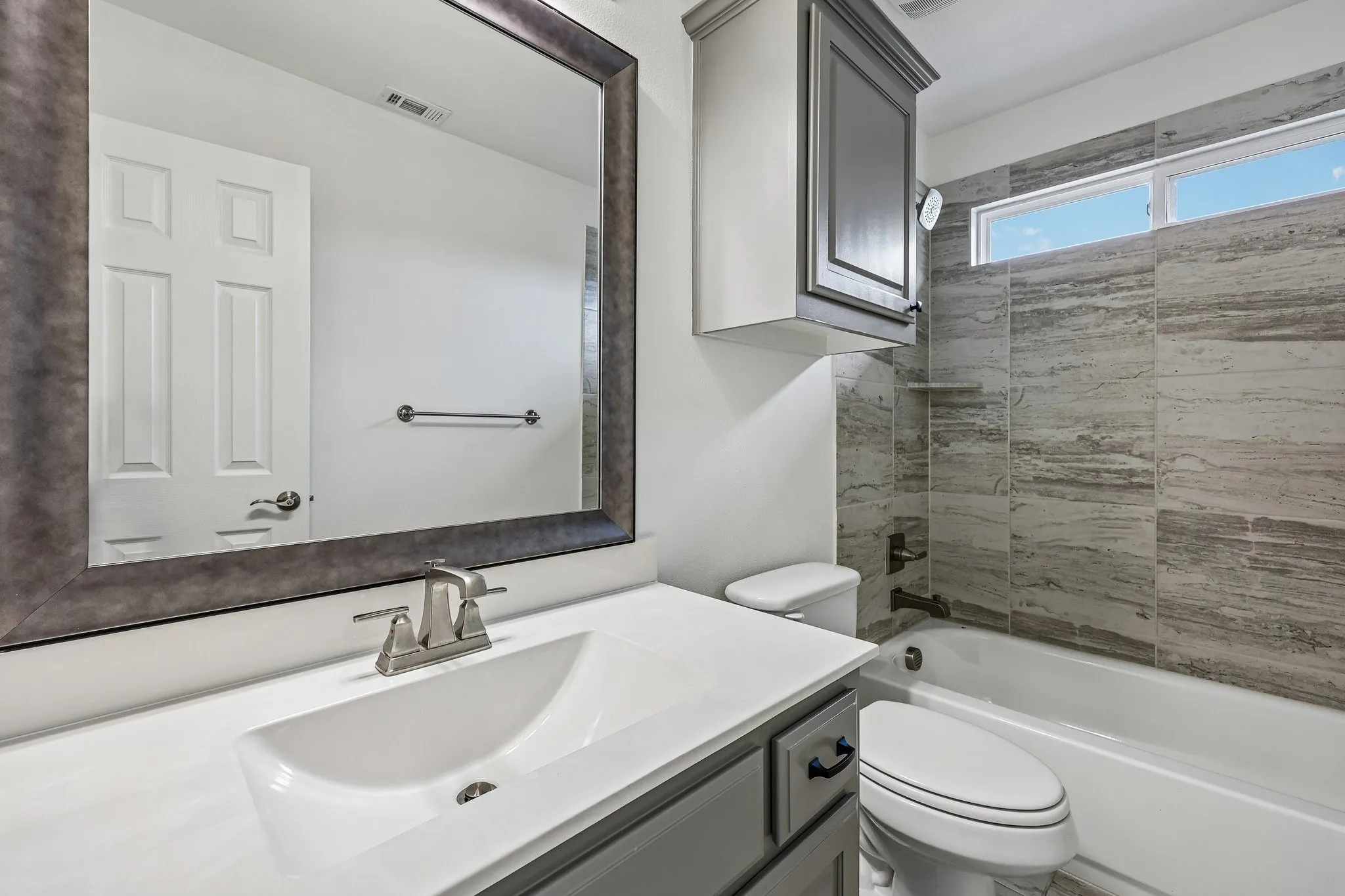 Modern vanity with a rectangular undermount sink, brushed nickel faucet, and a large framed mirror