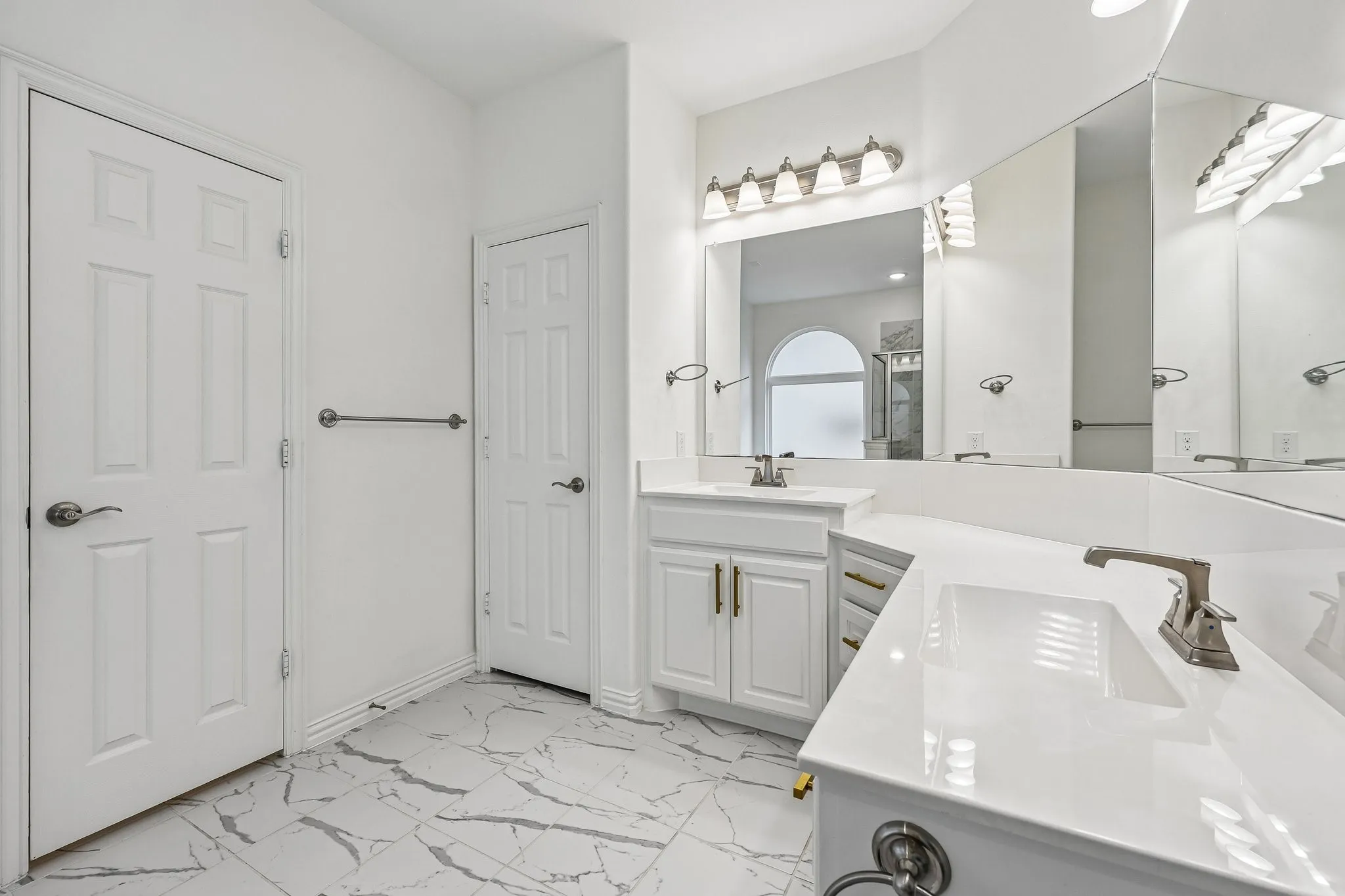 Dual vanity with white cabinetry and integrated sinks