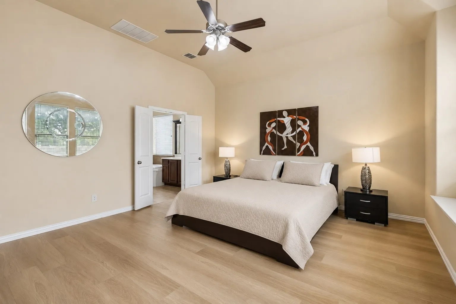 Spacious room featuring vaulted ceilings, wood-finish flooring, and a ceiling fan