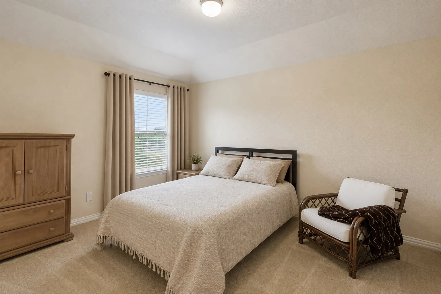 Neutral-toned bedroom featuring wall-to-wall carpeting, a single window with blinds and drapes, and a ceiling-mounted light fixture
