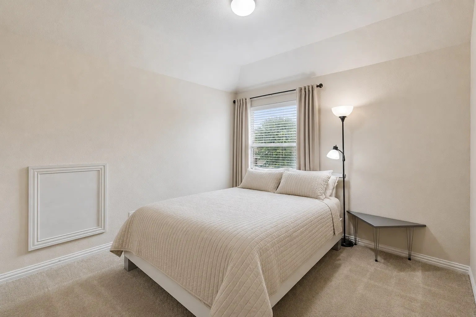Bedroom featuring neutral wall colors, carpeting, a tray ceiling, and a window with blinds and drapes