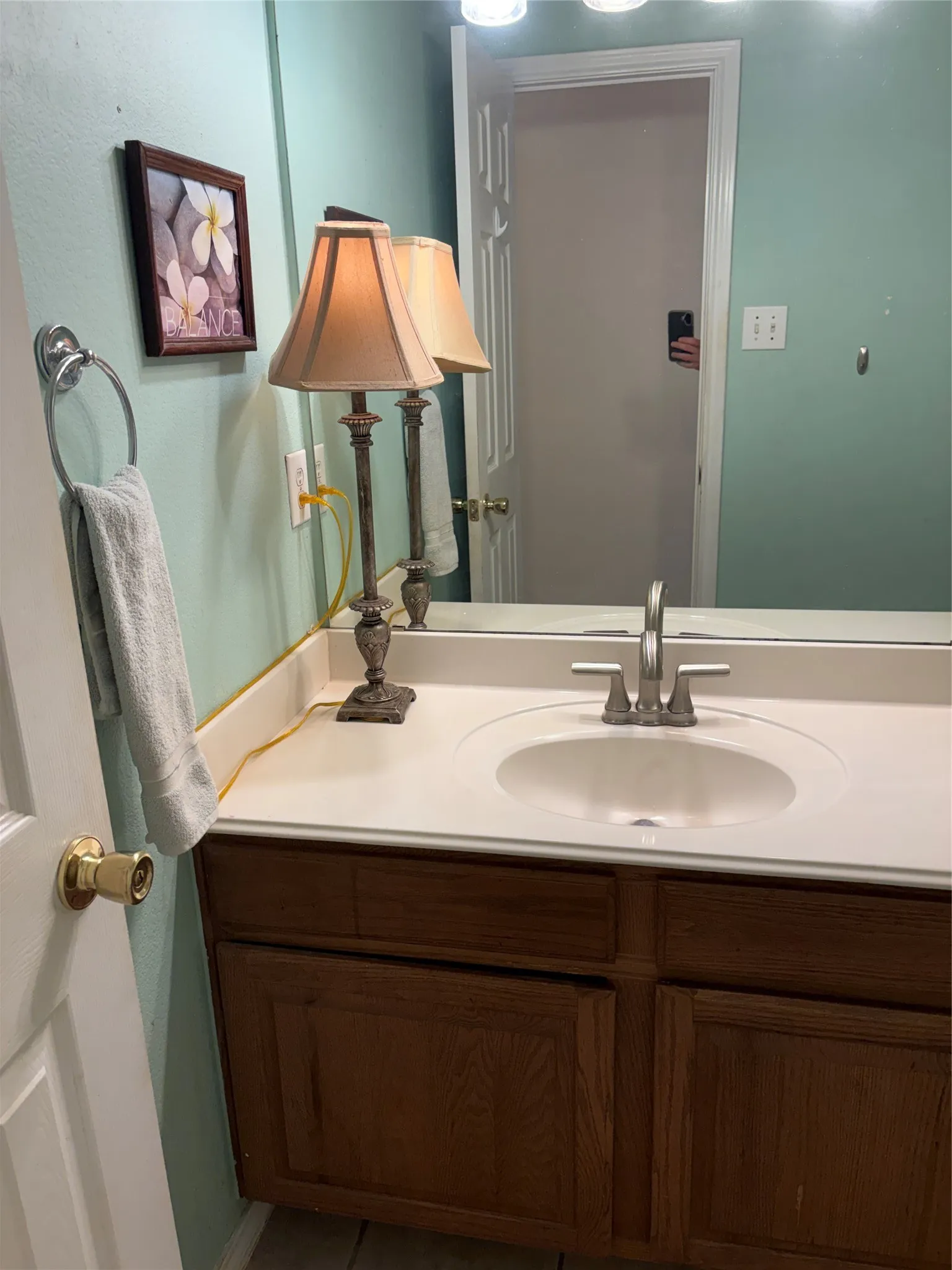 Vanity with a single basin, brushed nickel faucet, and wood-finish cabinetry