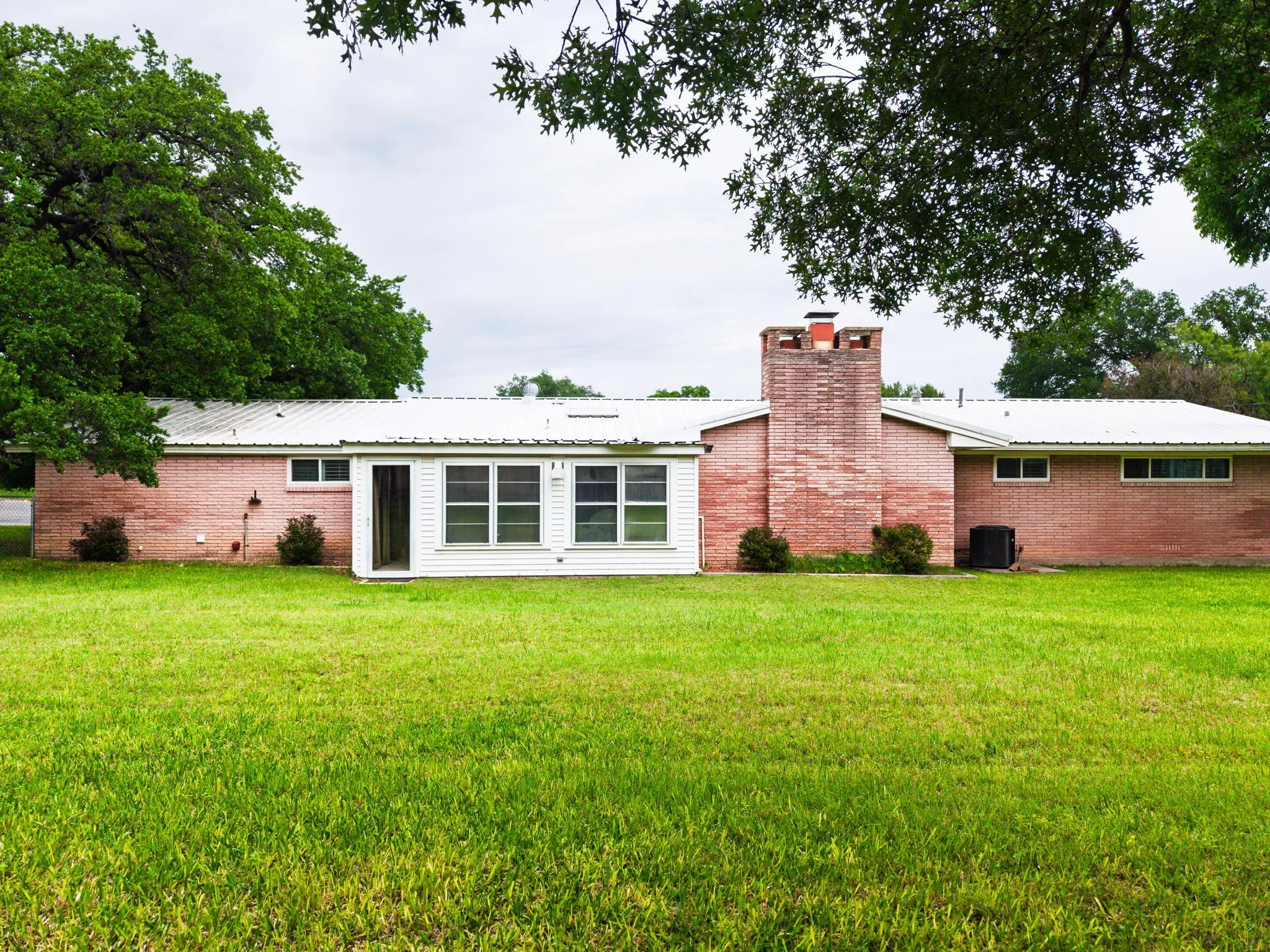 Expansive green lawn with a brick exterior home