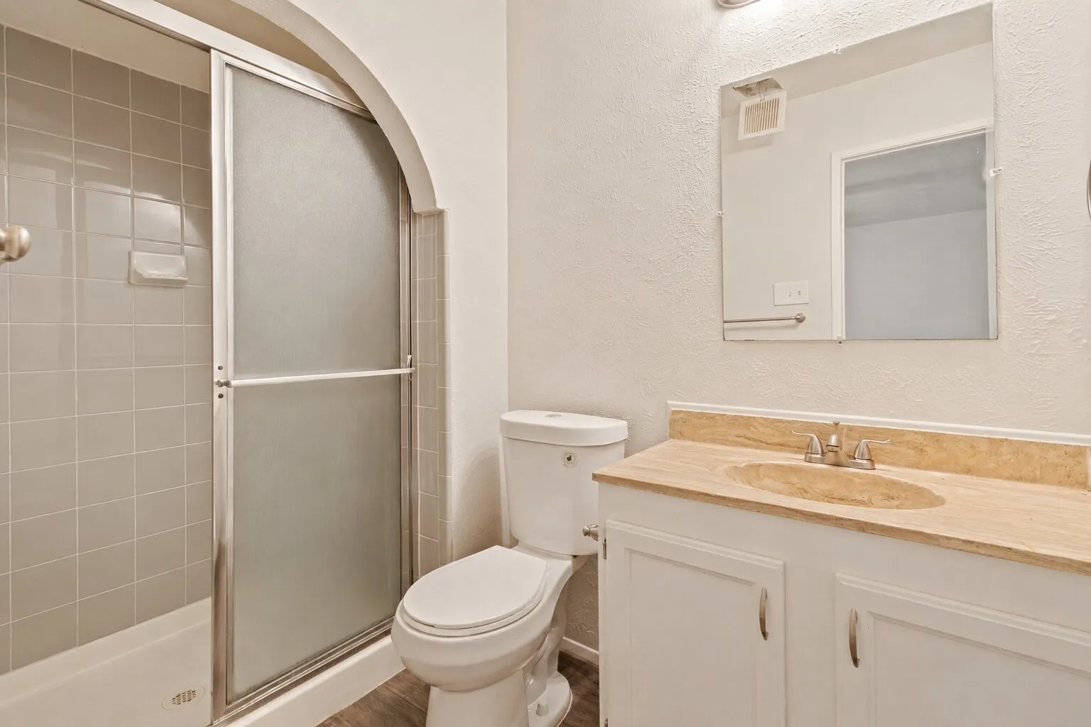 Bathroom featuring a vanity with a light-toned countertop, integrated sink, and white cabinetry