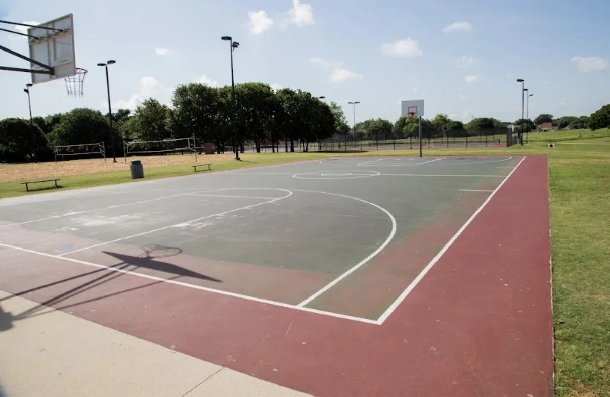 Paved basketball court with multiple hoops and painted court lines