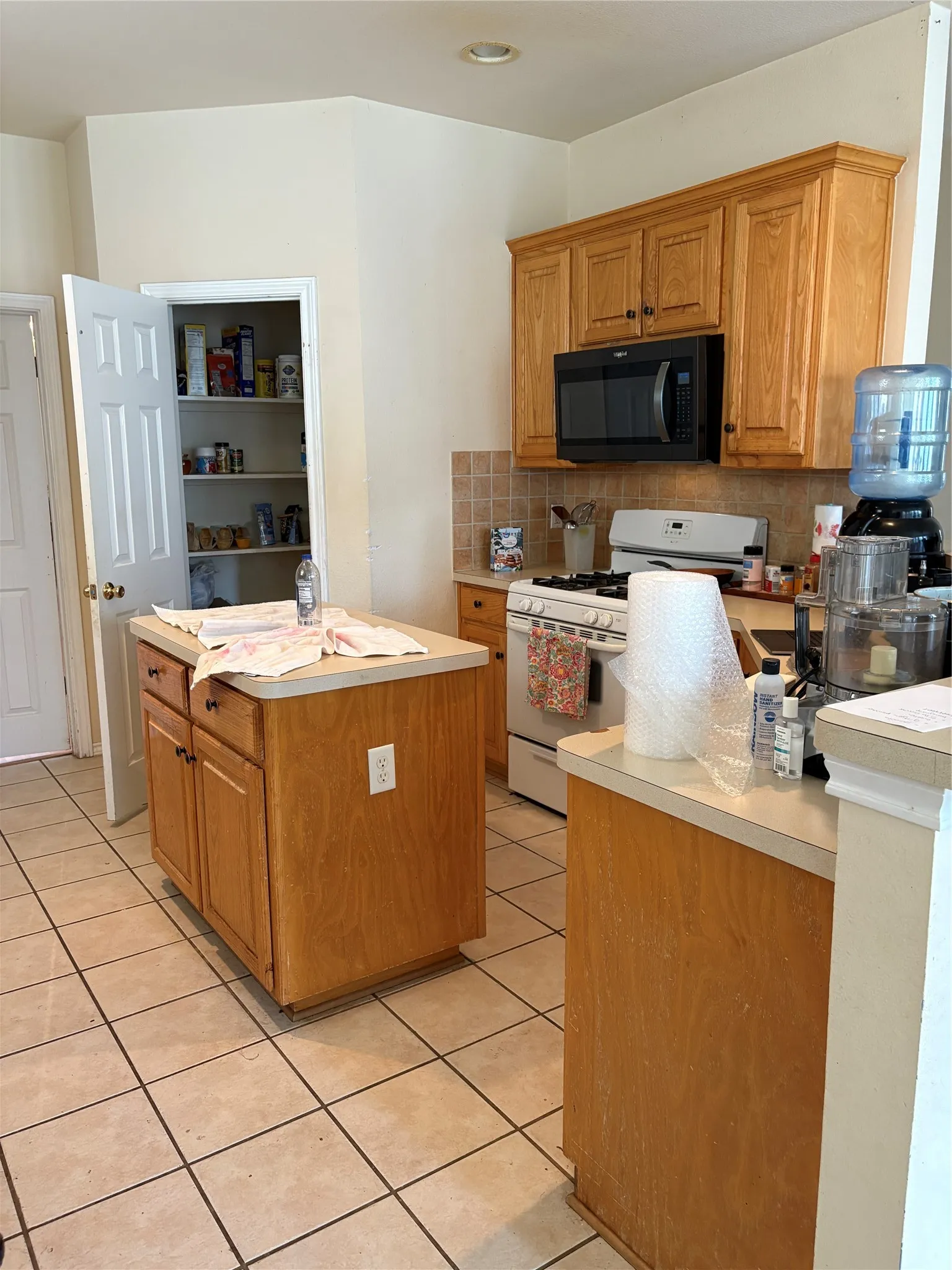 Kitchen featuring wood-finish cabinetry, tile flooring, and a built-in pantry