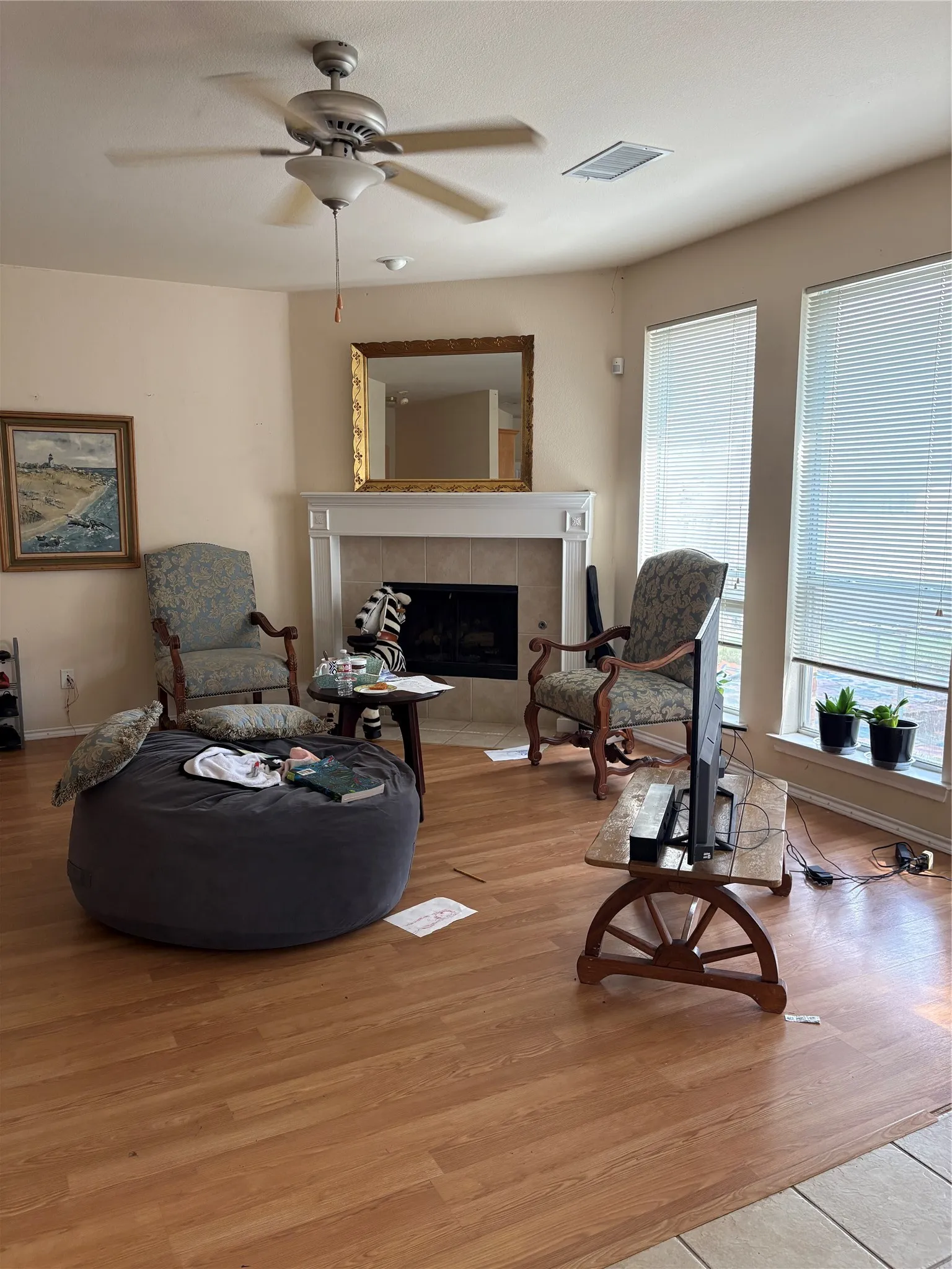Central ceiling fan, recessed lighting, corner fireplace with mantel, window blinds, and wood-finish flooring