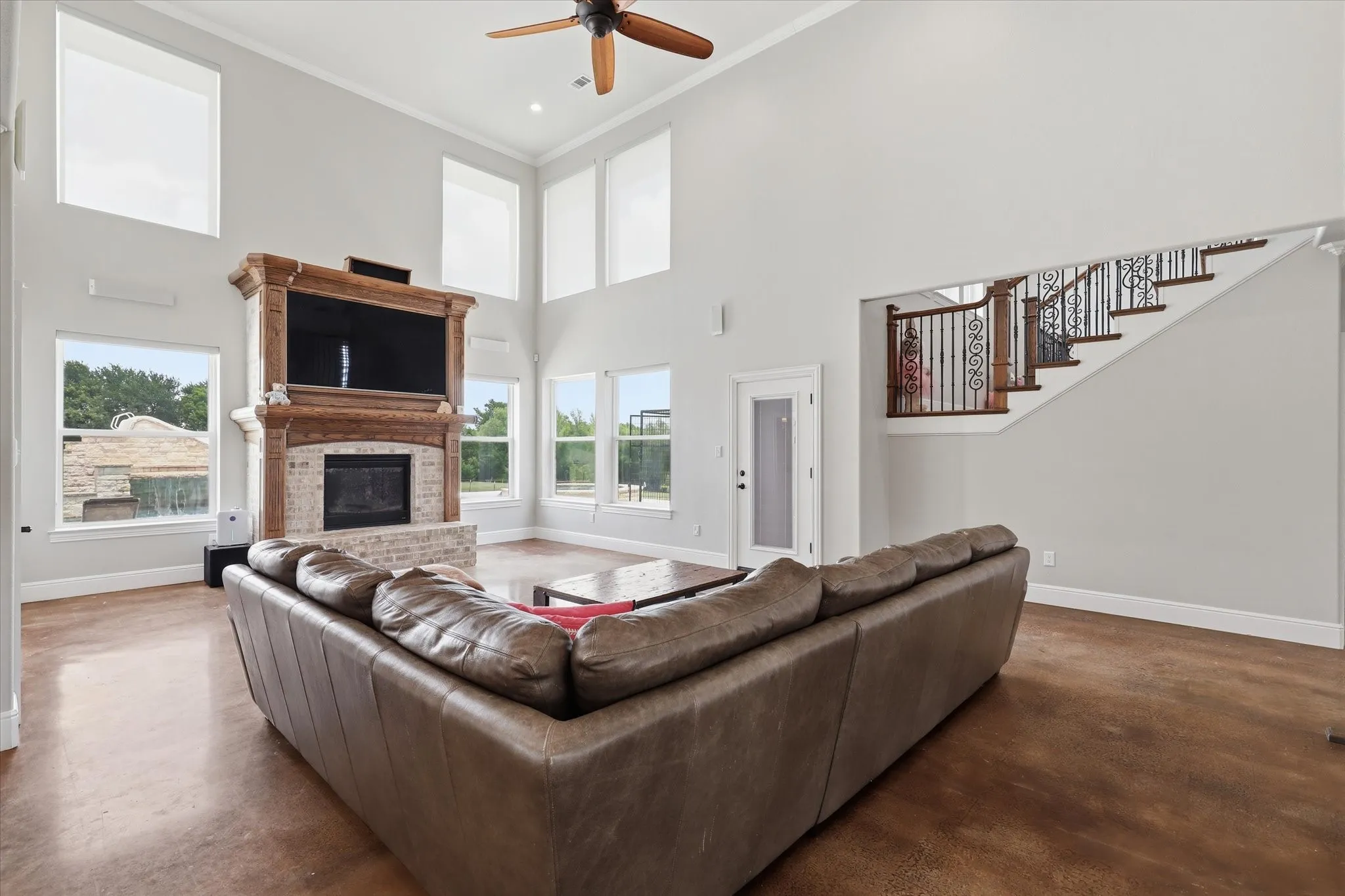 Great room featuring a two-story ceiling, multiple windows, and wood-finish flooring