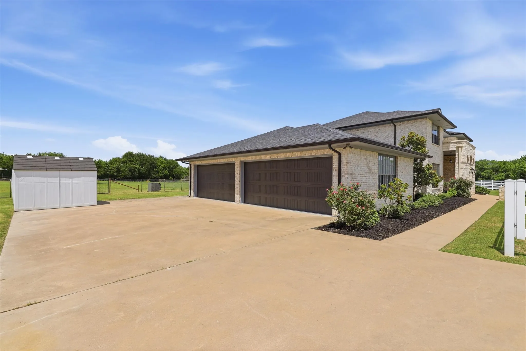 Light brick exterior featuring a two-car garage with dark wood-finish doors