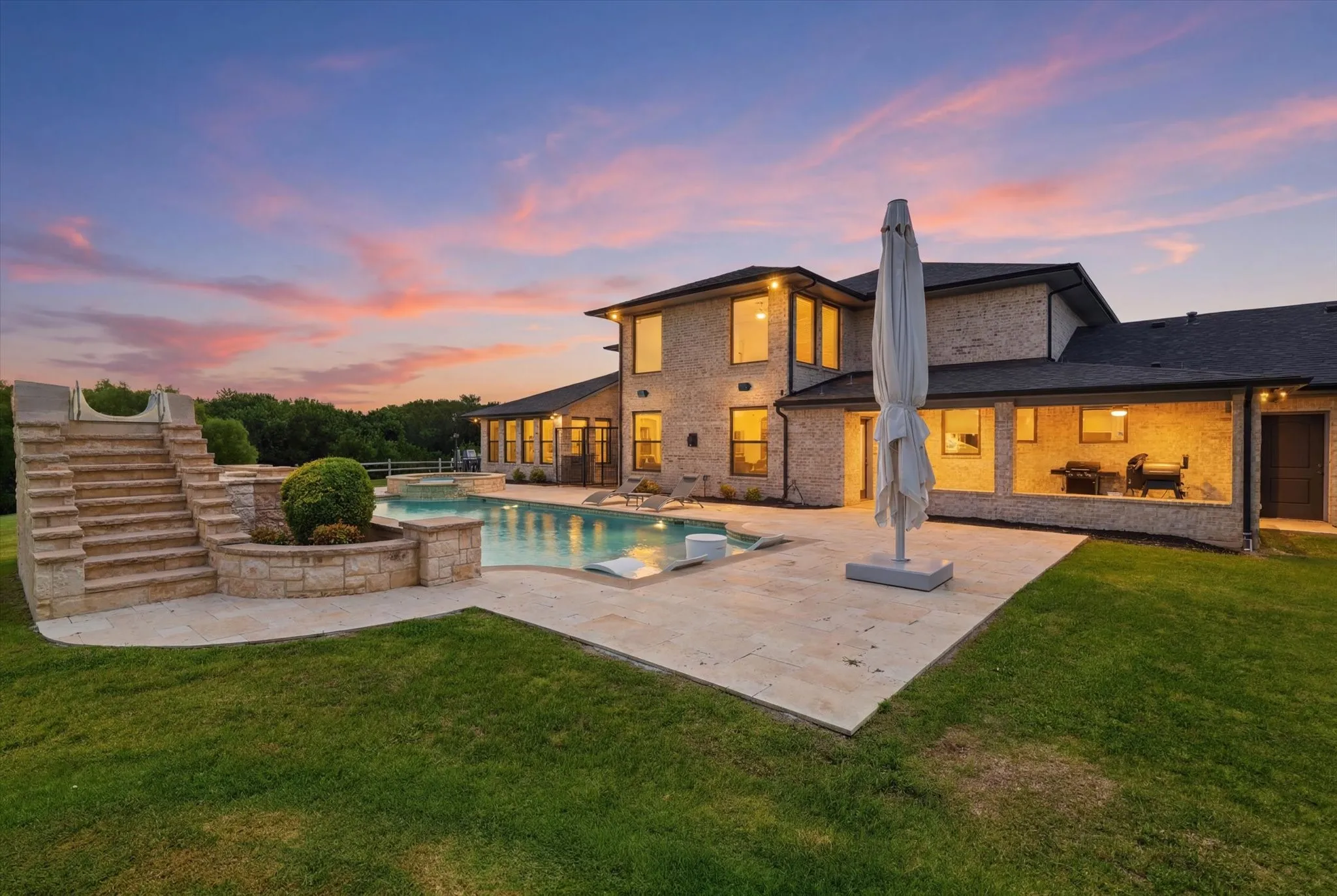 Stone exterior residence featuring an in-ground swimming pool, a tiered stone staircase, and a covered patio