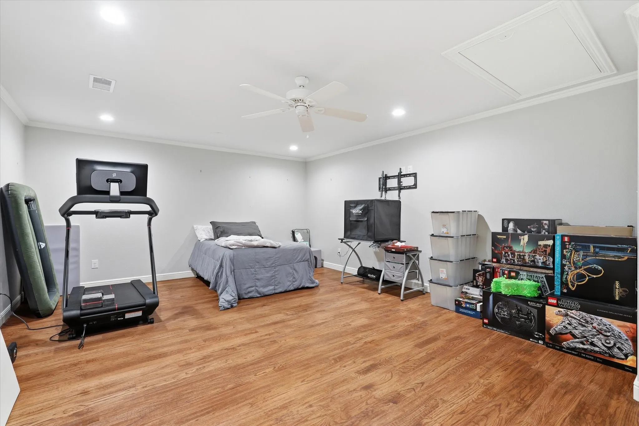 Spacious room featuring wood-finish flooring, recessed lighting, and a ceiling fan