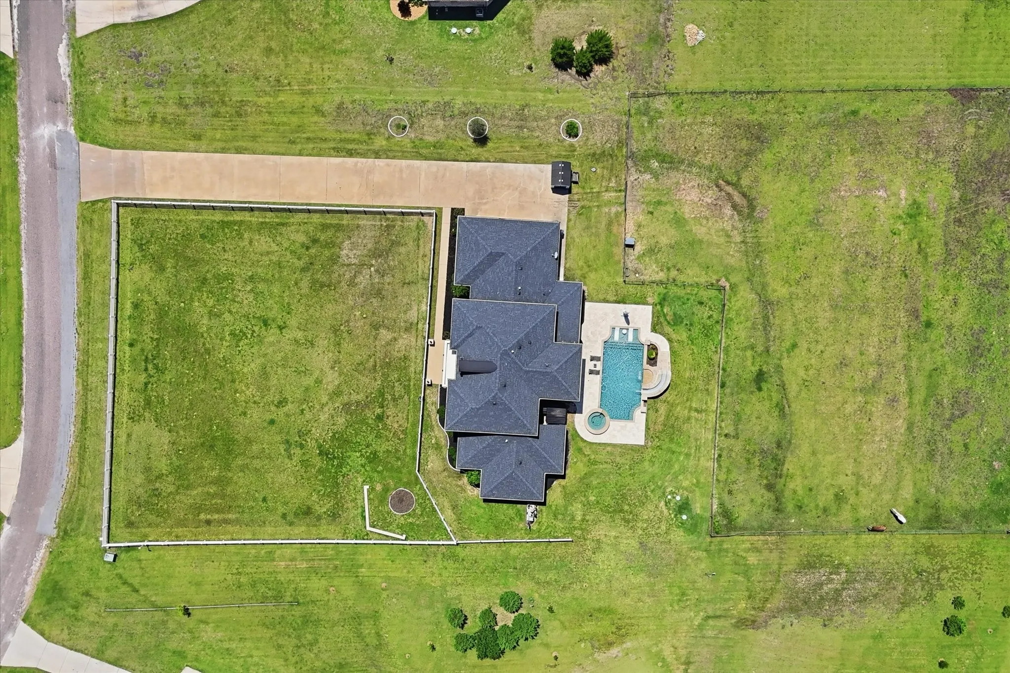 Expansive property featuring a multi-gabled roofline, a private driveway, a rectangular swimming pool, and an integrated spa