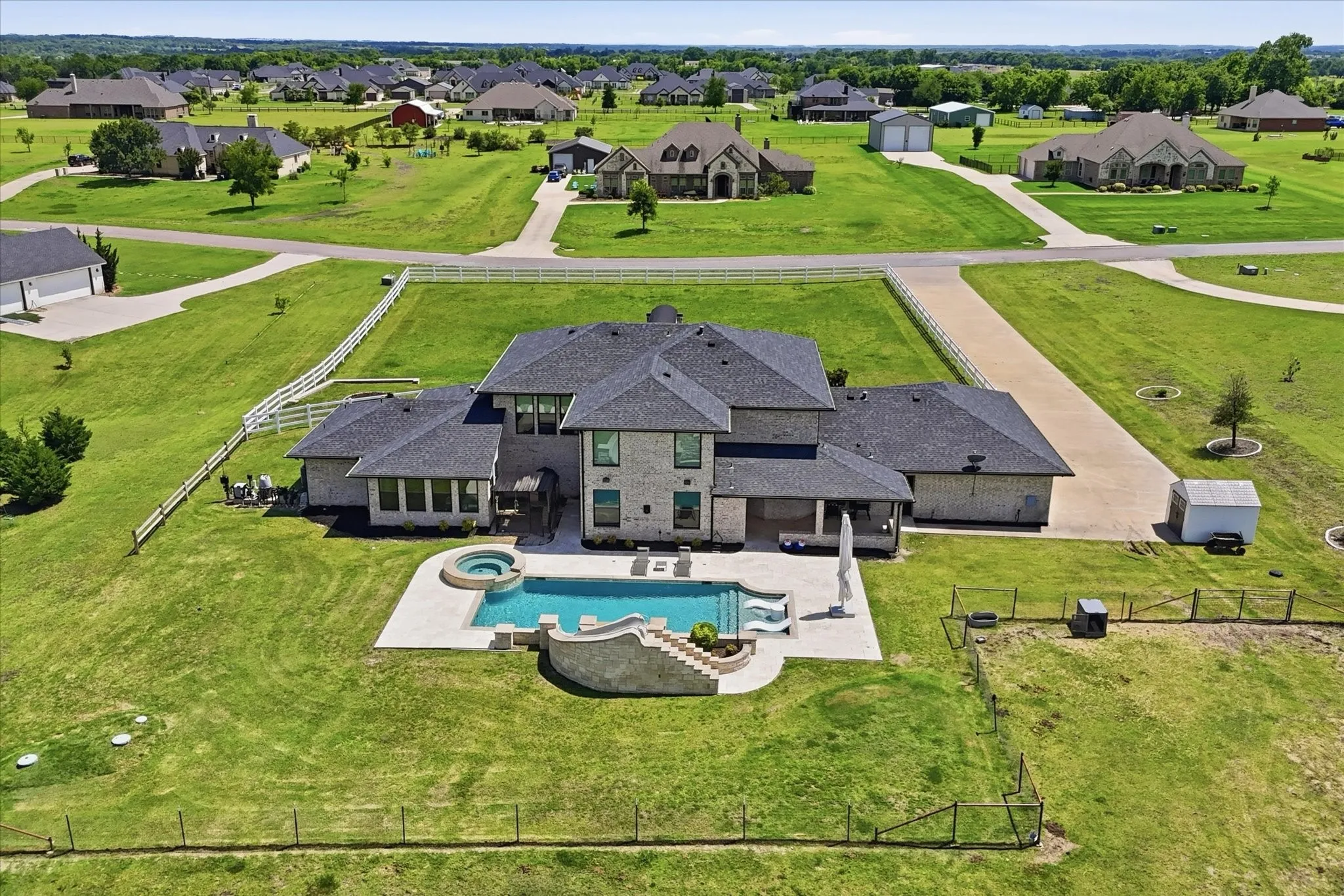 Stone veneer exterior with a dark shingle roof