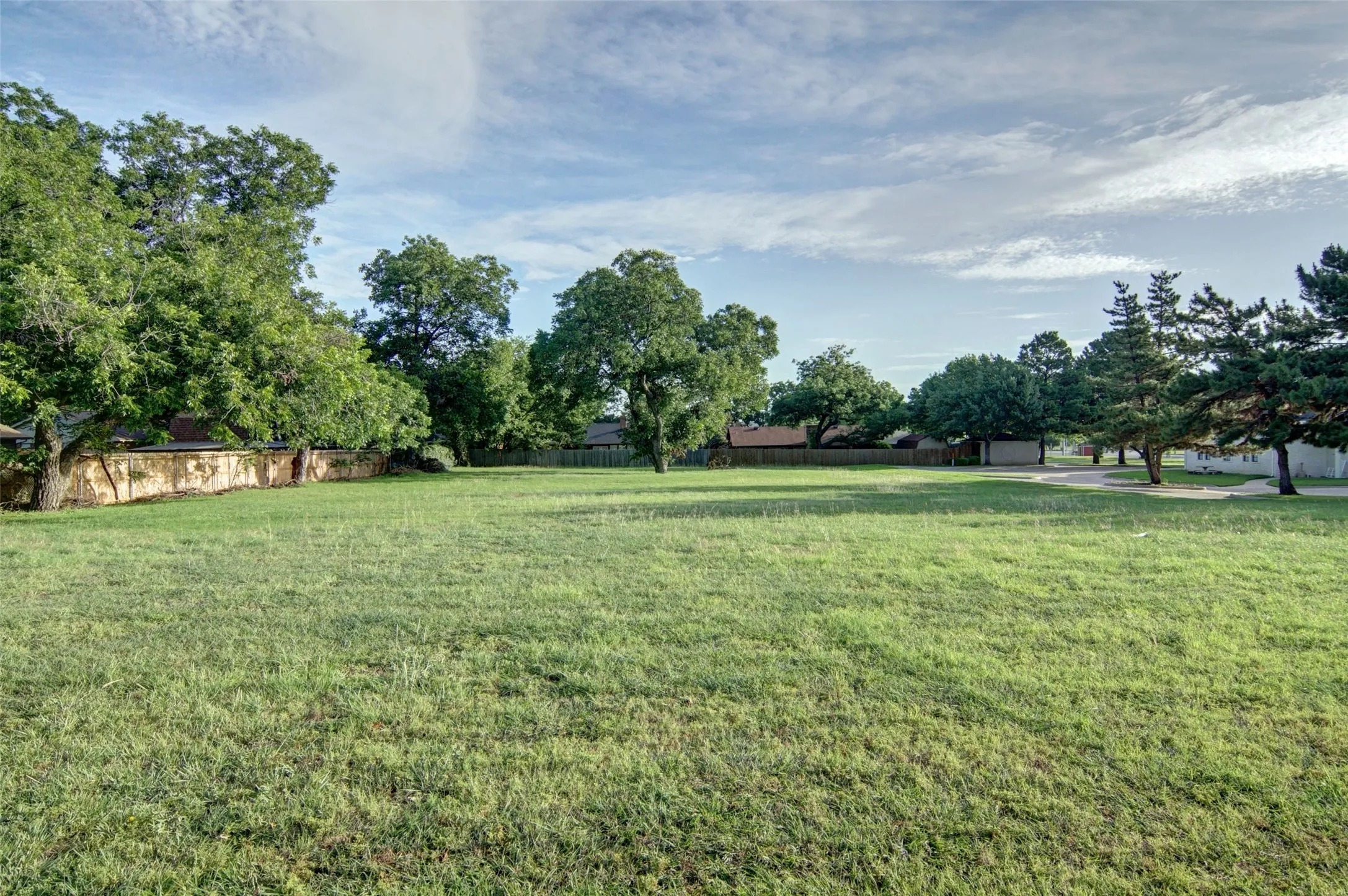 Level lot with several mature trees.