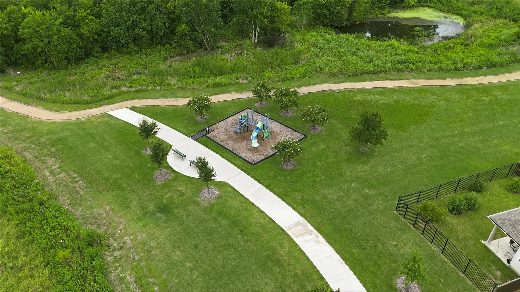 Expansive grounds featuring manicured lawn, mature tree canopy, and a central playground structure with equipment