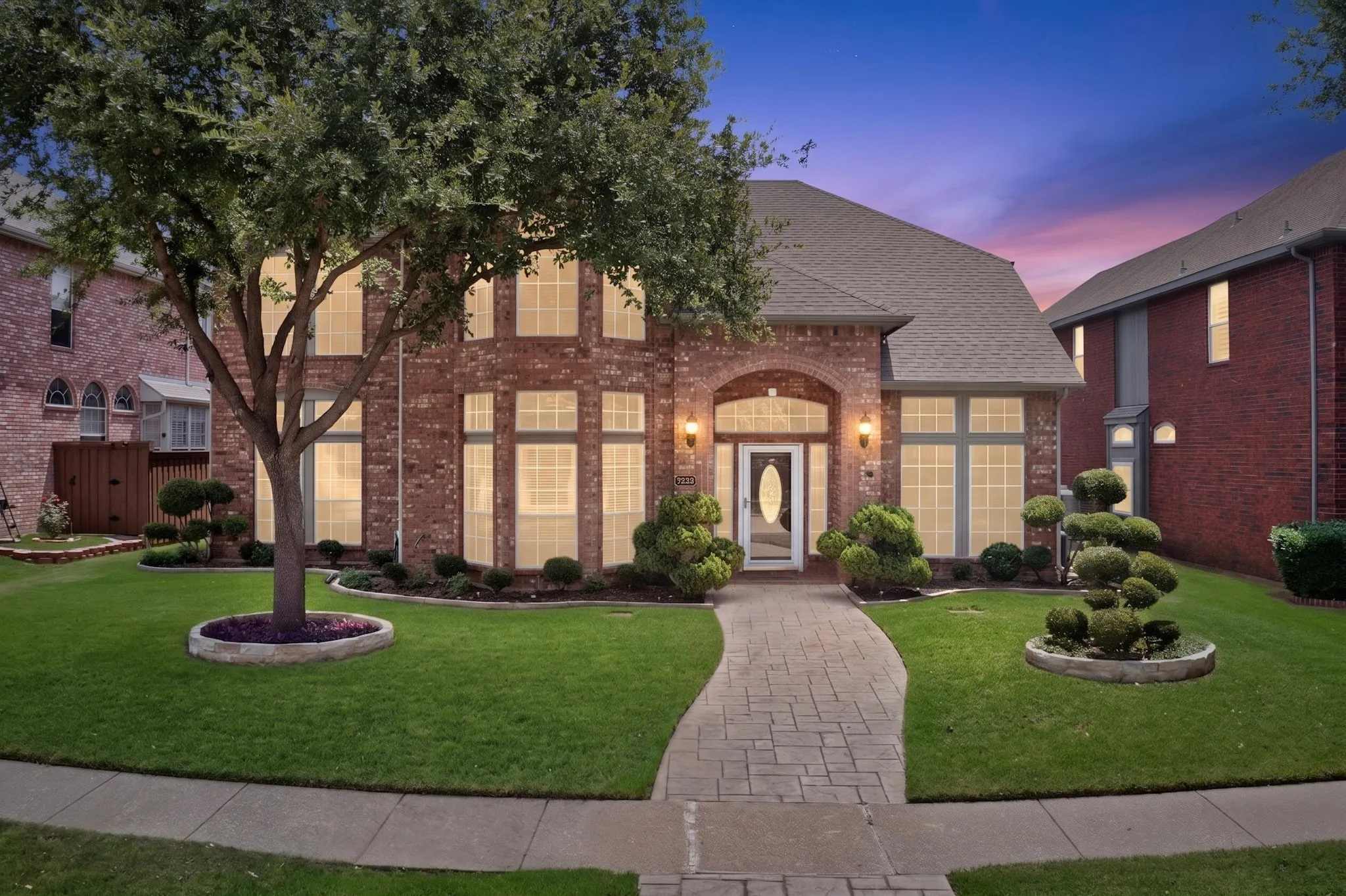 Brick facade residence featuring a front entry with an arched portico and sidelights