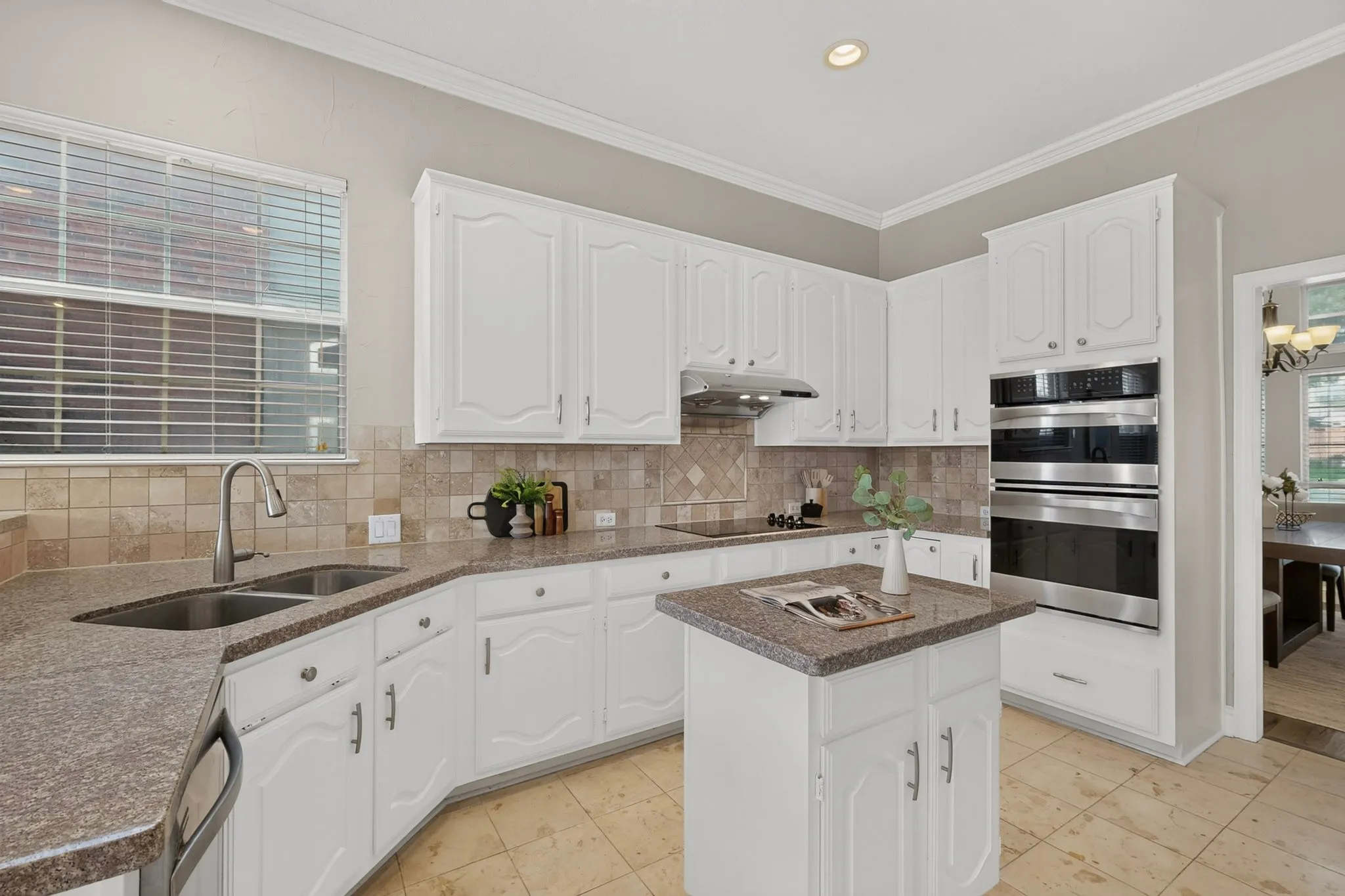 Kitchen featuring white cabinetry, stone-finish countertops, stainless steel double wall ovens, a built-in cooktop, and a tile backsplash