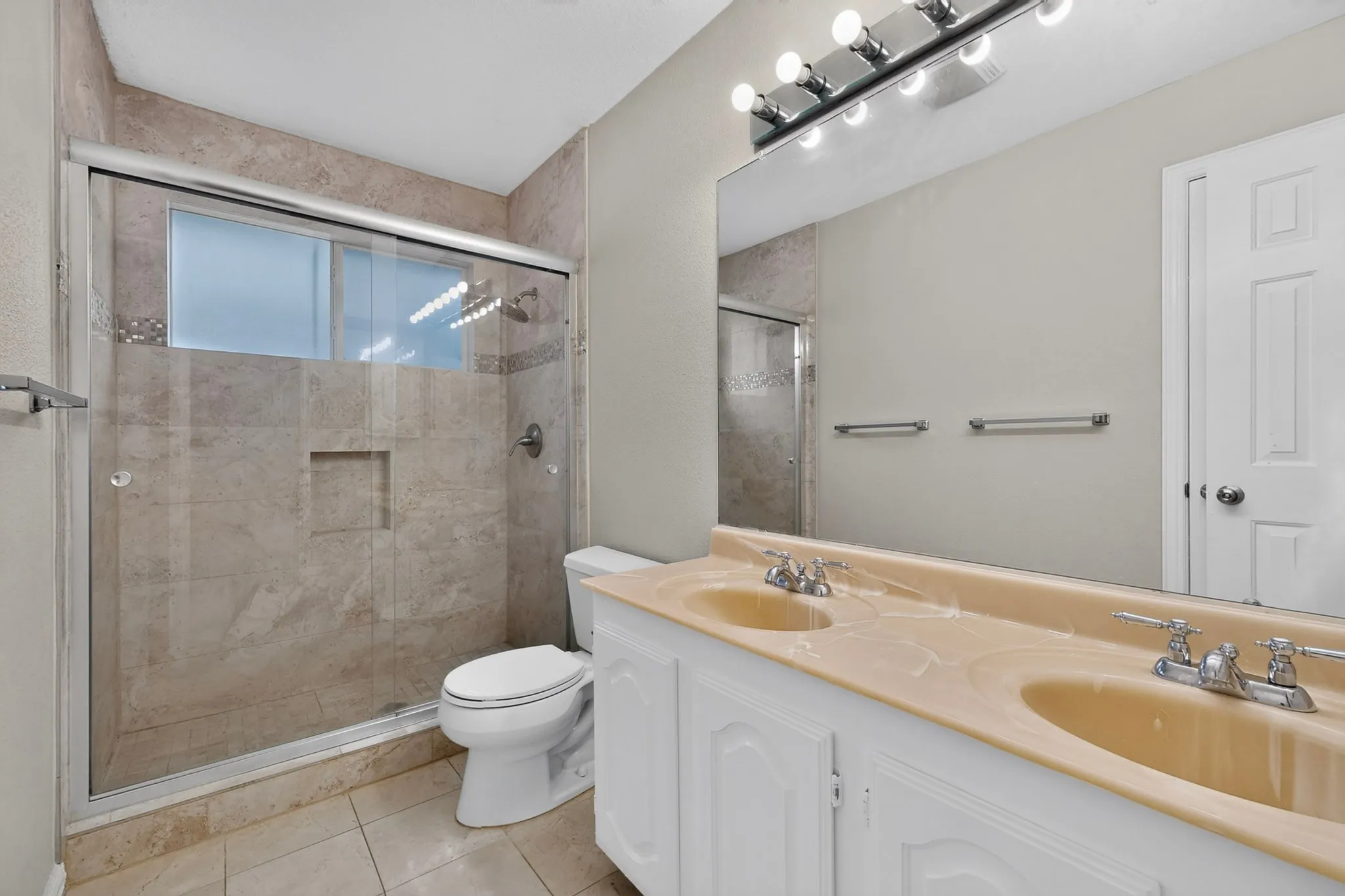 Bathroom featuring a double vanity with integrated sinks and chrome fixtures